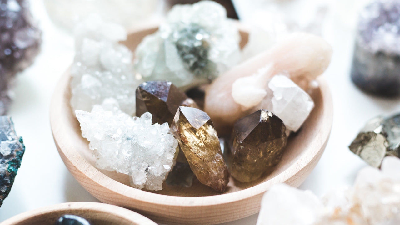 Healing crystals for nervous system regulation arranged in a wooden bowl with Smoky Quartz points and Clear Quartz clusters