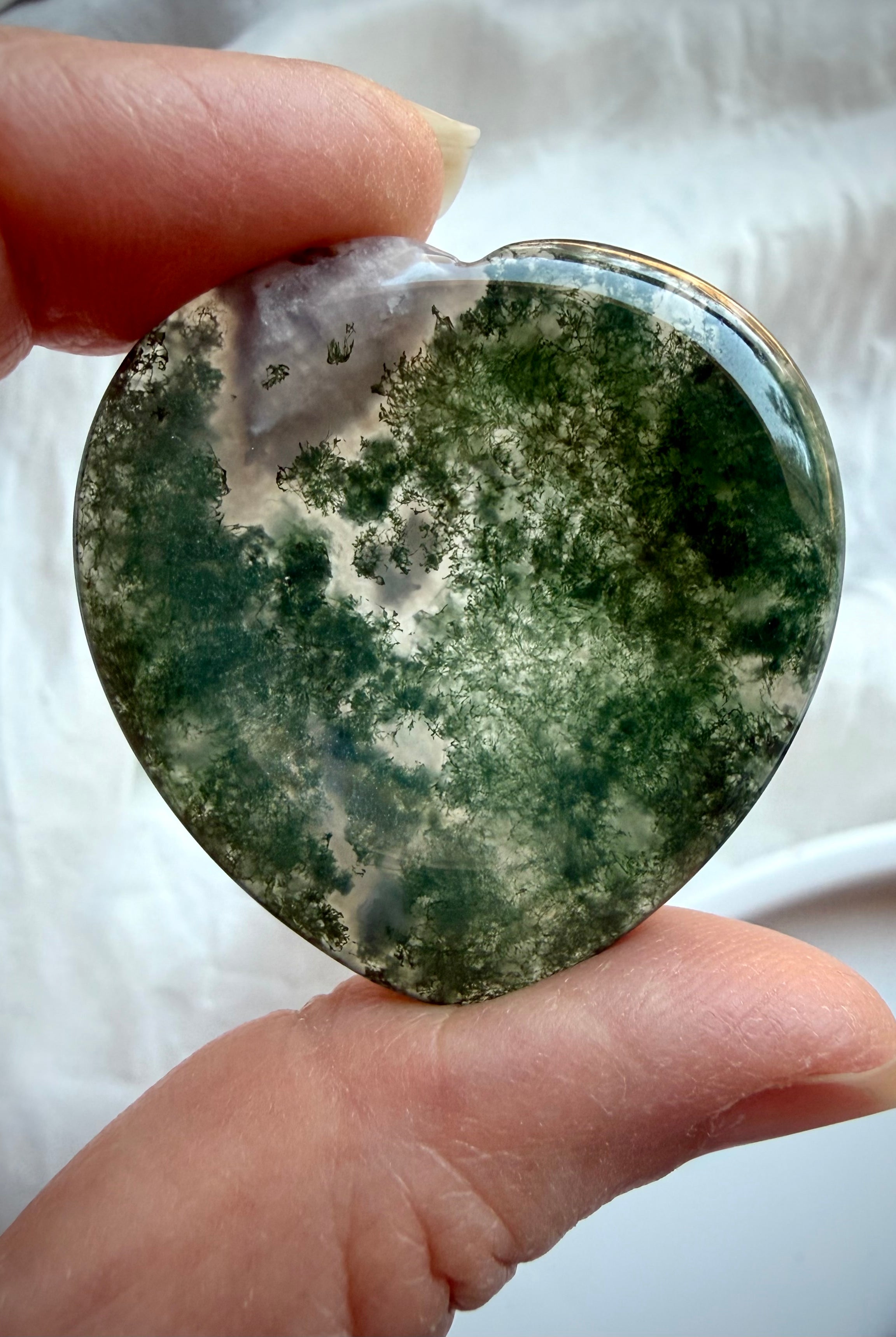 Polished Moss Agate heart worry stones showing natural variation in green inclusions and clear quartz