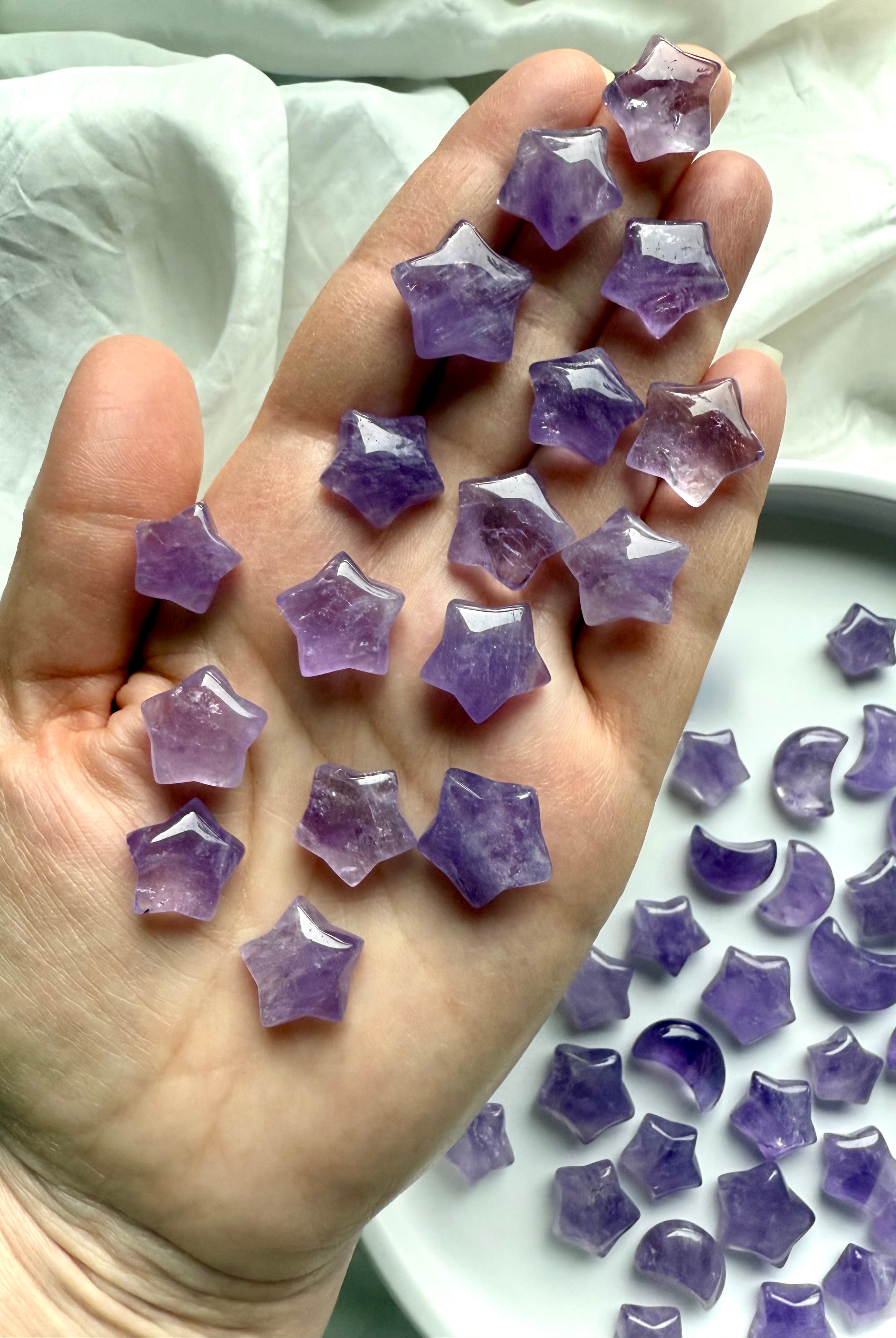 Mini Amethyst crystal stars held in hand, showing natural color variation and polished finish for calming and intuitive energy