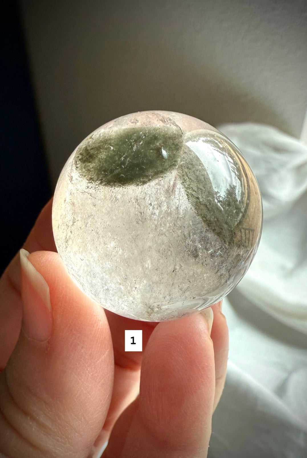 close-up of garden quartz sphere – clear crystal with moss-like inclusions for spiritual growth