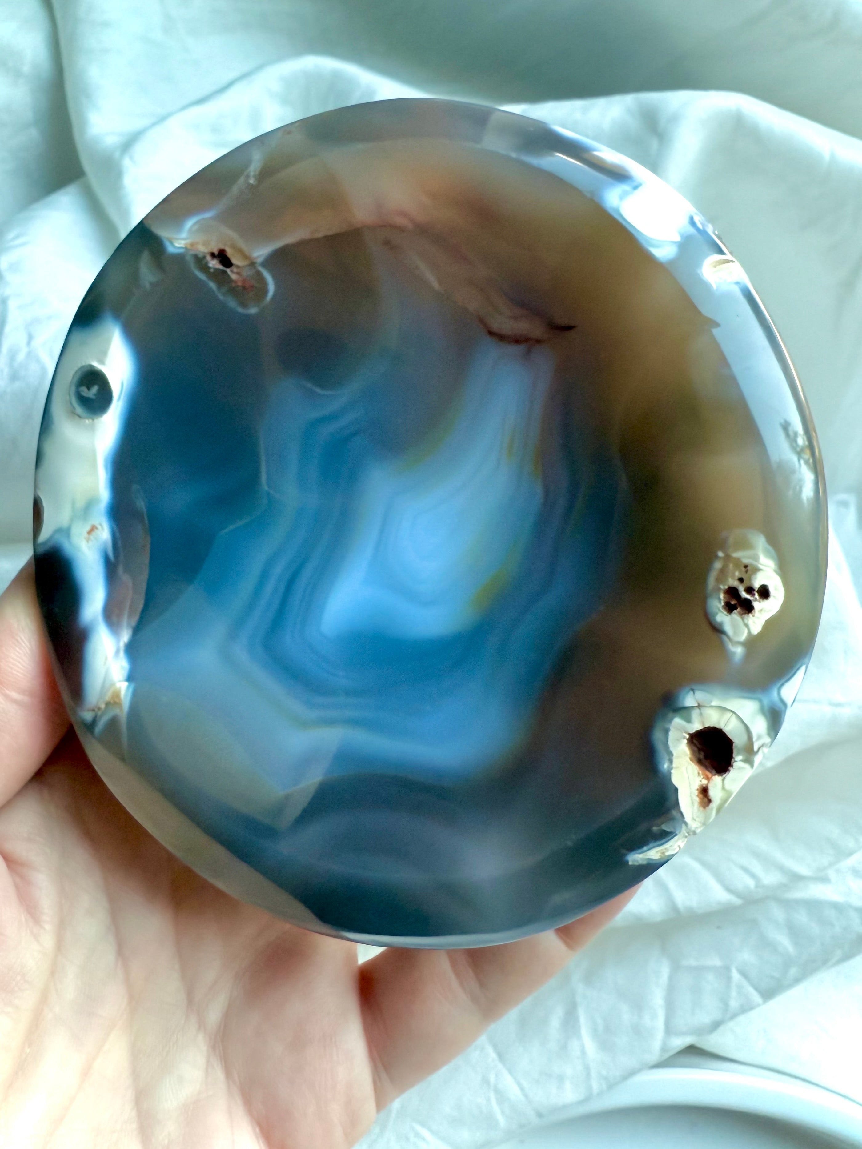 Polished Orca Agate offering bowl cradled in hand, highlighting its ocean-inspired layers and grounding earth tones