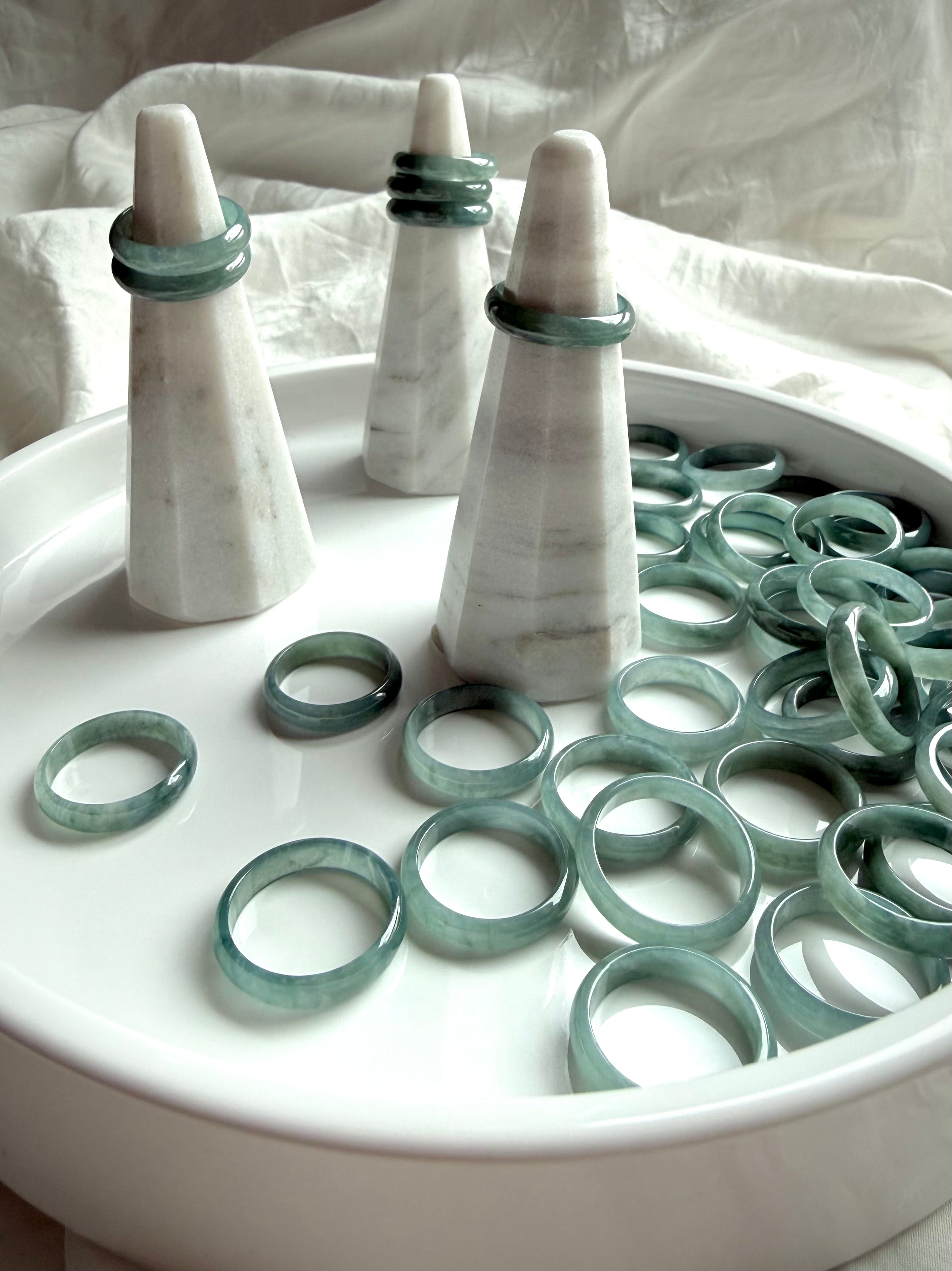 Rounded Blue Water jade ring bands on display tray with stands, natural jadeite jewelry