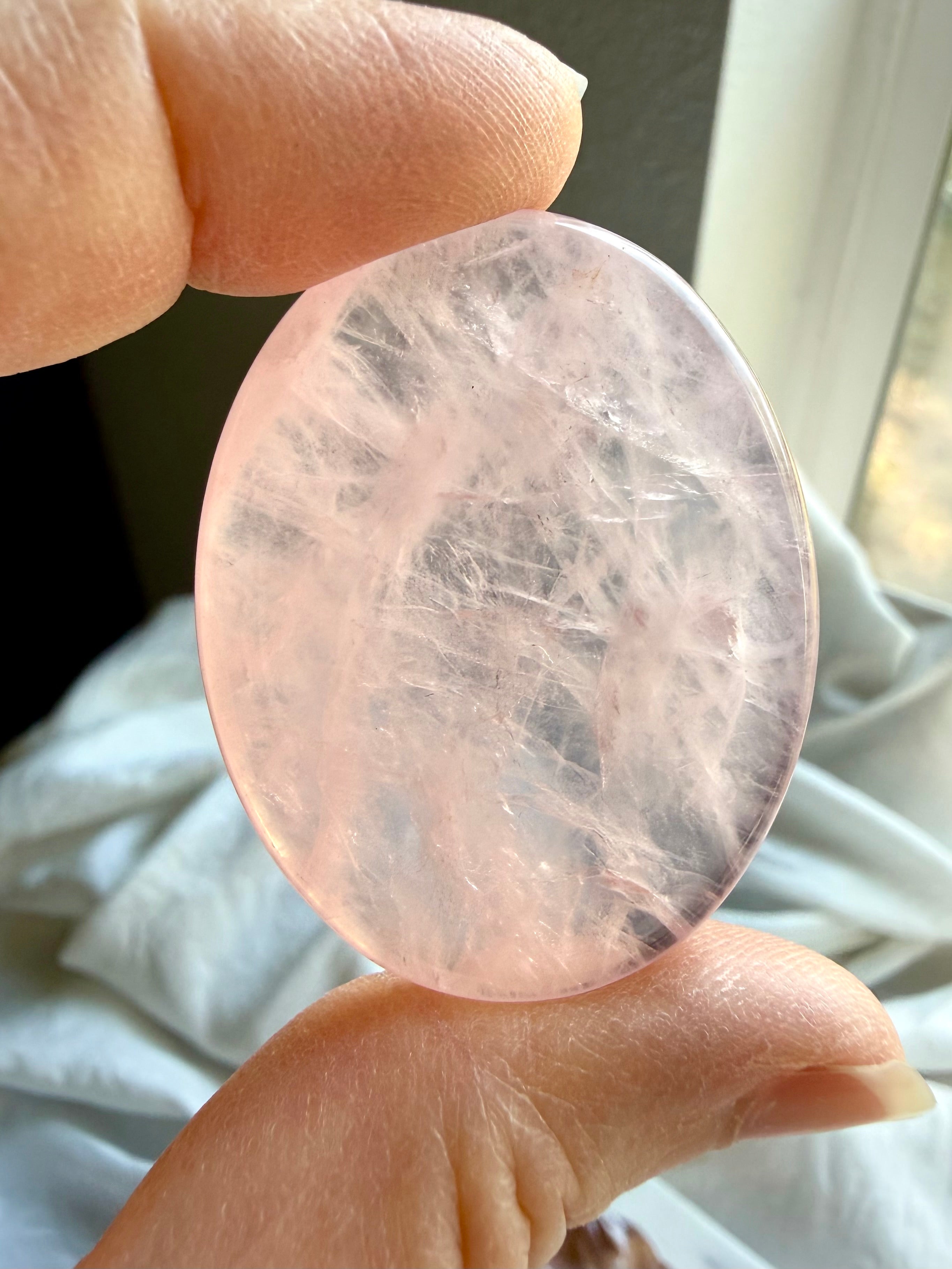 rose quartz worry stone close up for emotional healing love and heart chakra balance