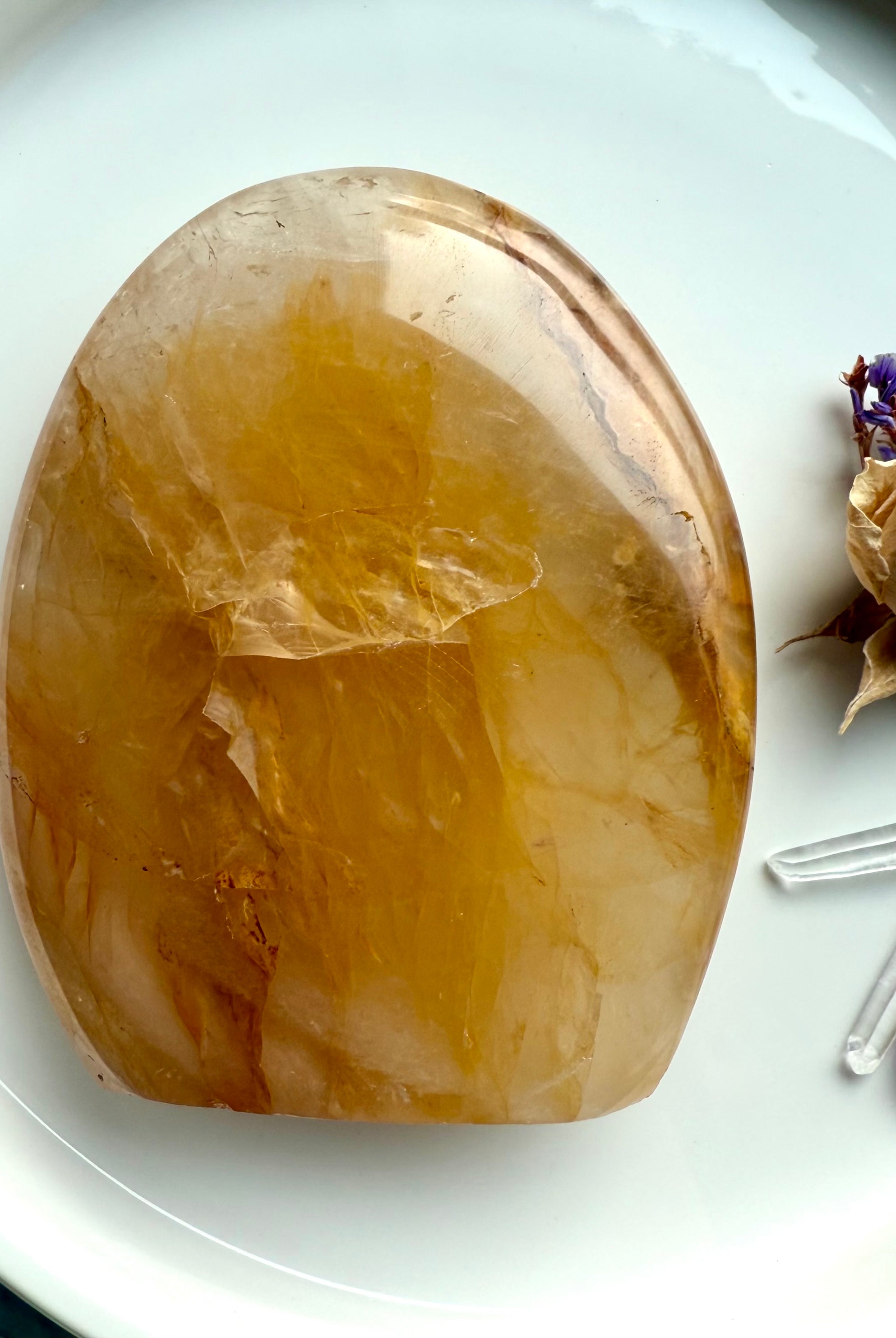 Flatlay of polished Golden Healer Quartz freeform with radiant golden color & luminous healing energy