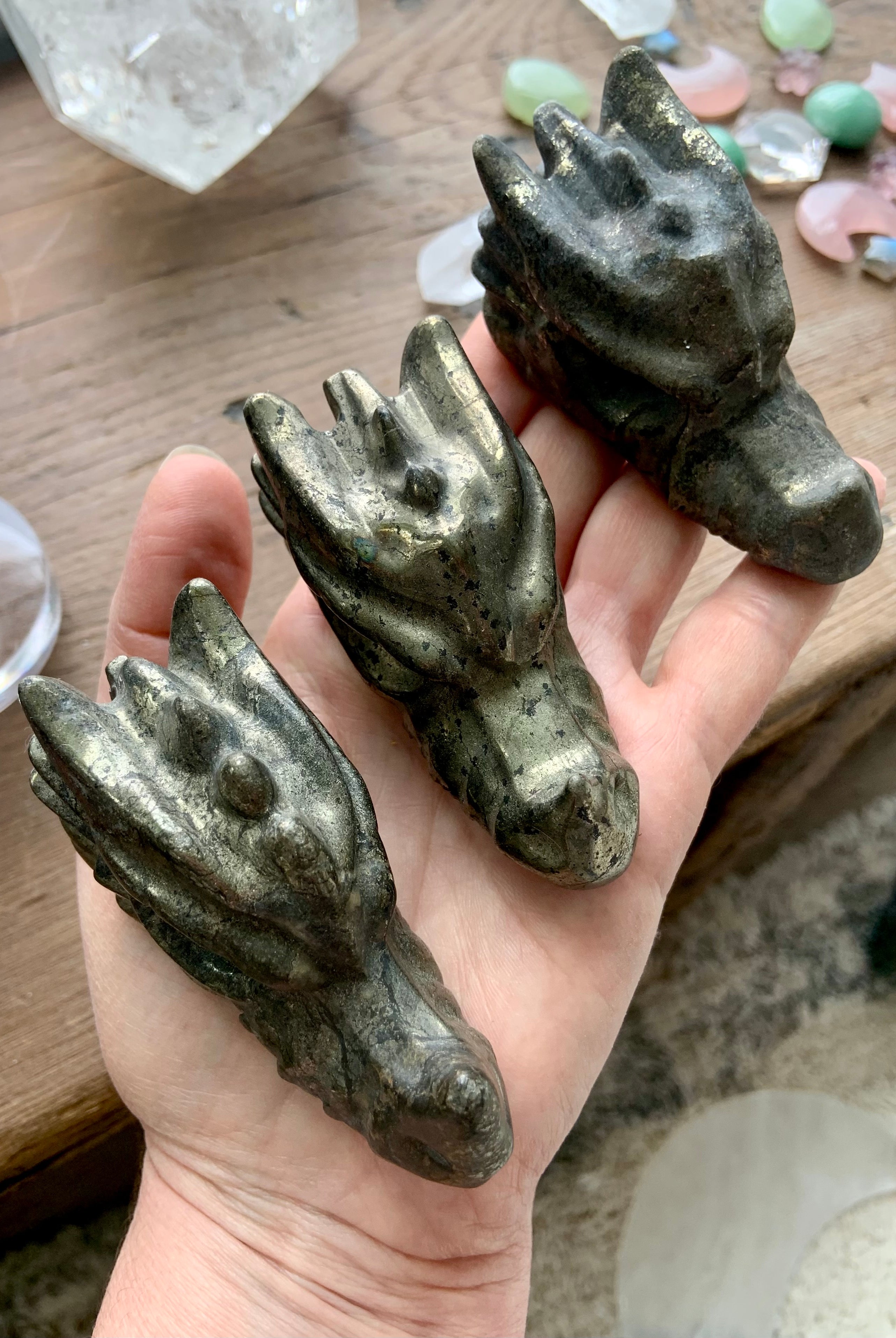 Pyrite crystal dragon carvings shown in hand, metallic gold pyrite stone for grounding, protection and abundance