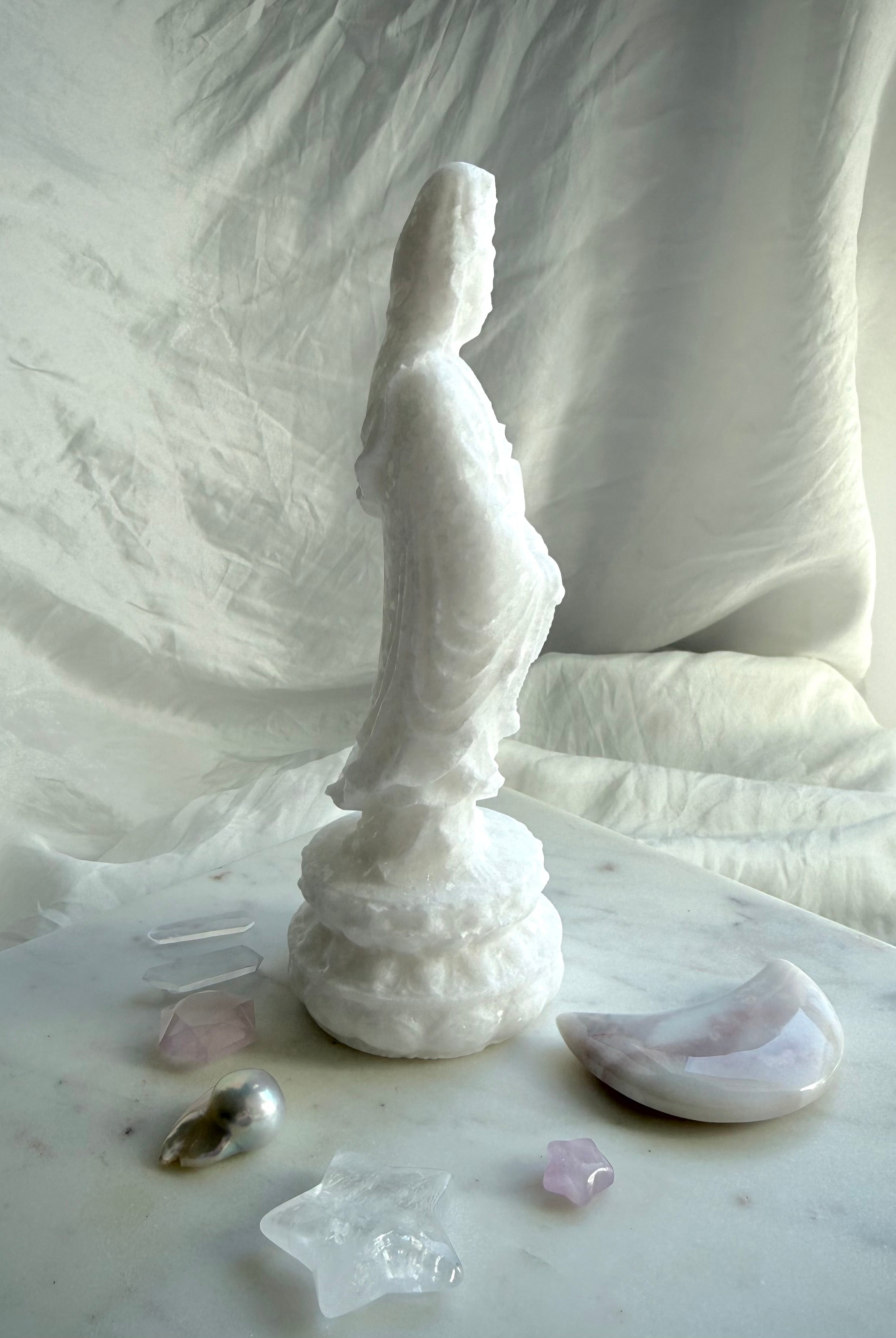 Three-quarter view of White Jade Goddess carving with soft matte finish and natural translucency