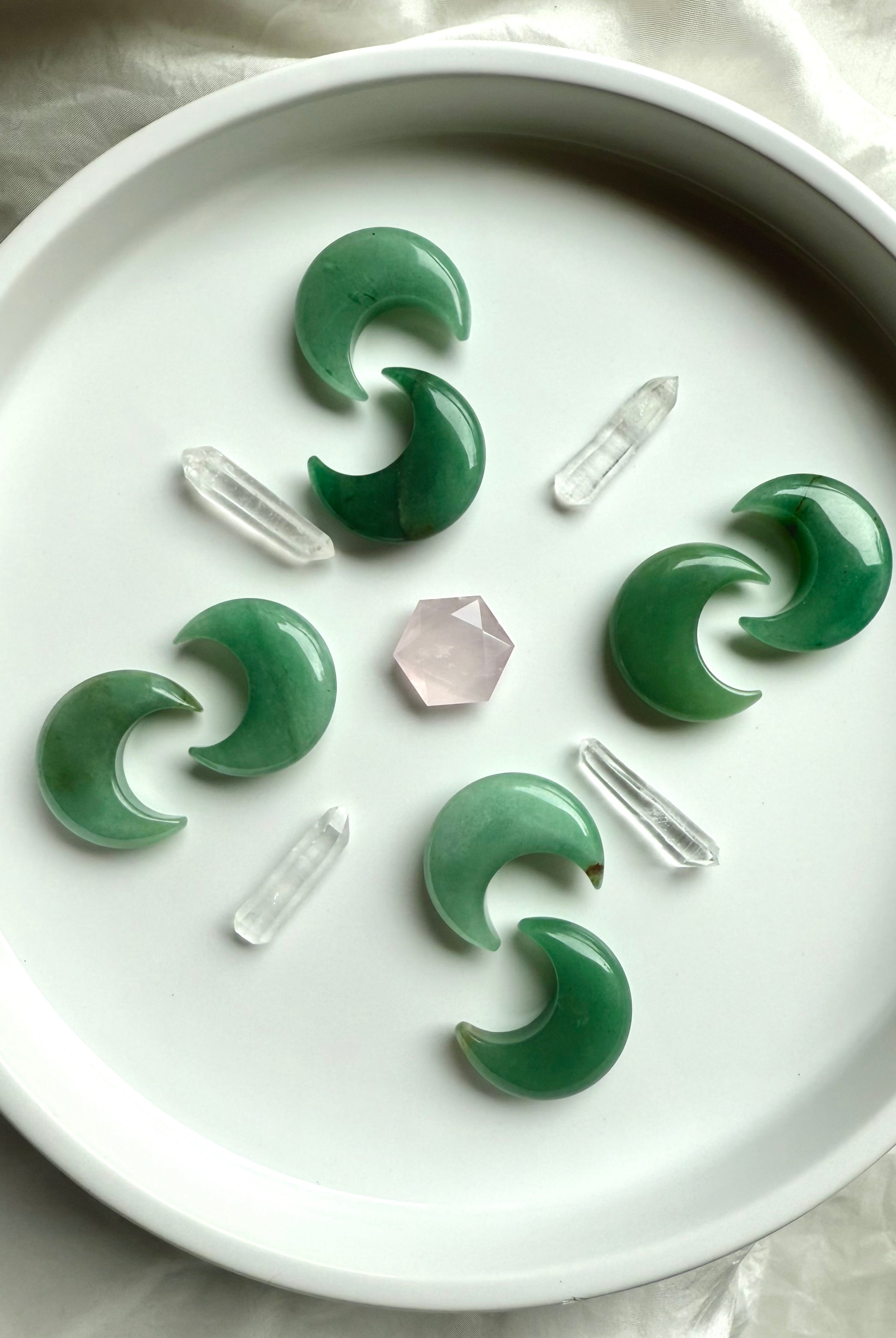 Crystal grid with Green Aventurine moons, clear quartz points, and rose quartz hexagon center, sacred geometry for Heart Chakra healing