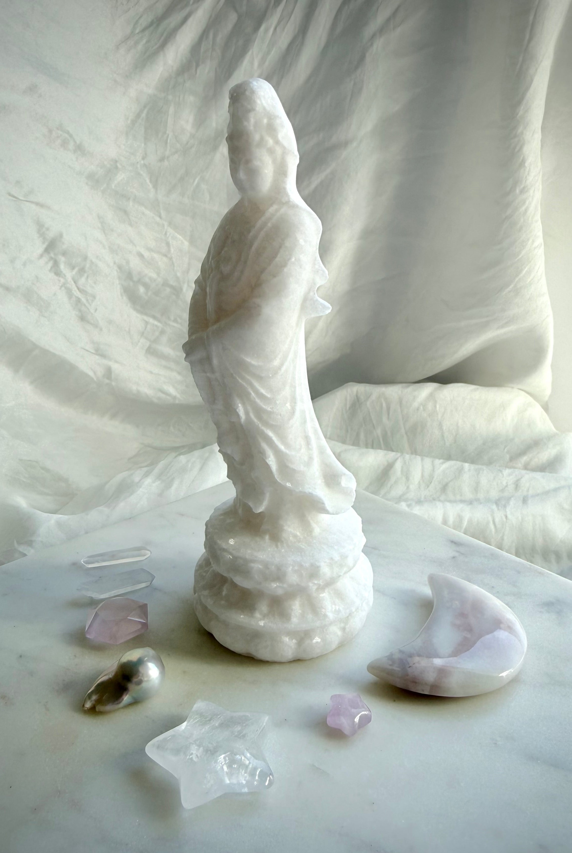 White Jade Goddess of Mercy statue standing on lotus pedestal with serene expression