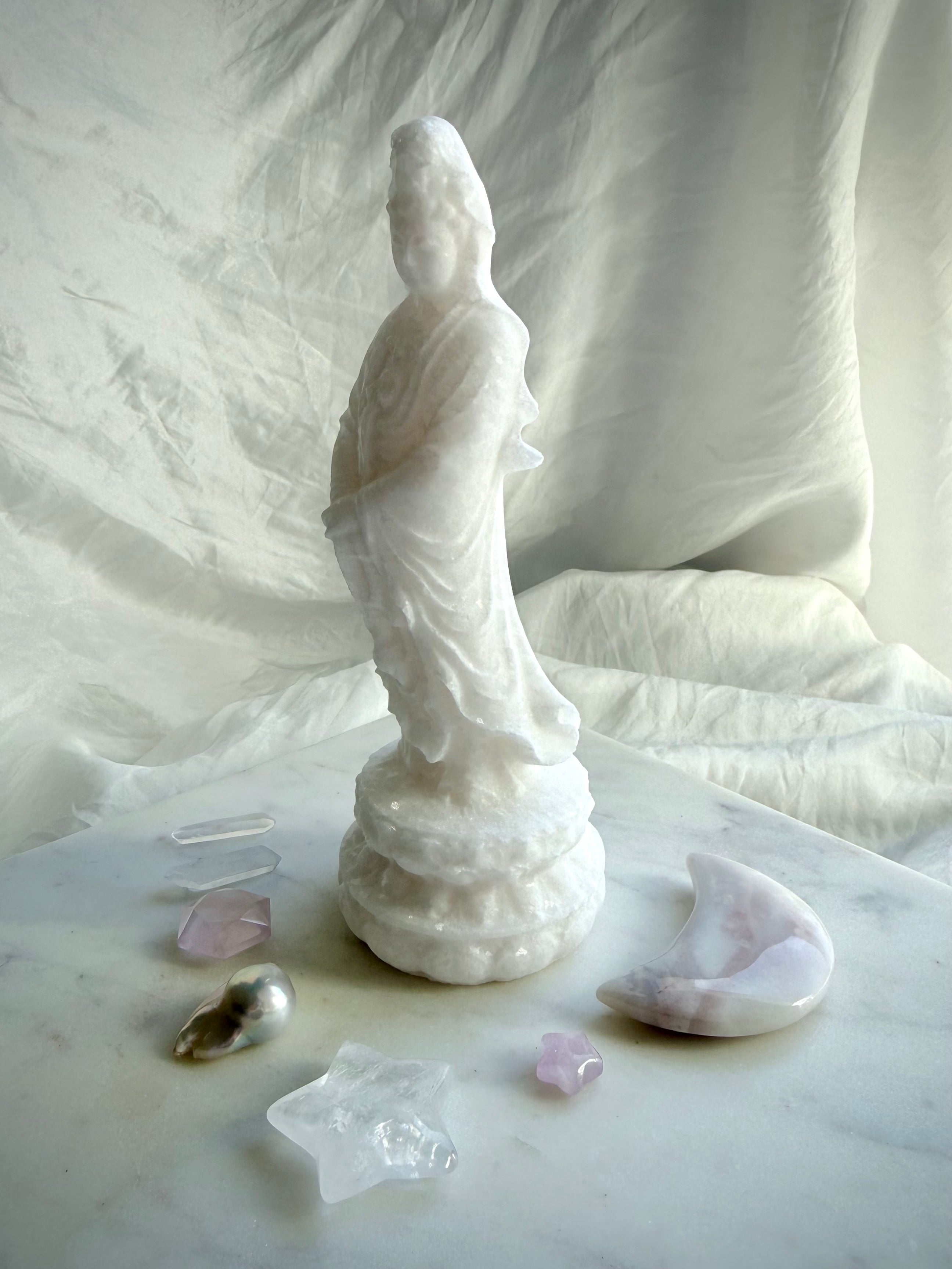 White Jade Goddess of Mercy statue standing on lotus pedestal with serene expression