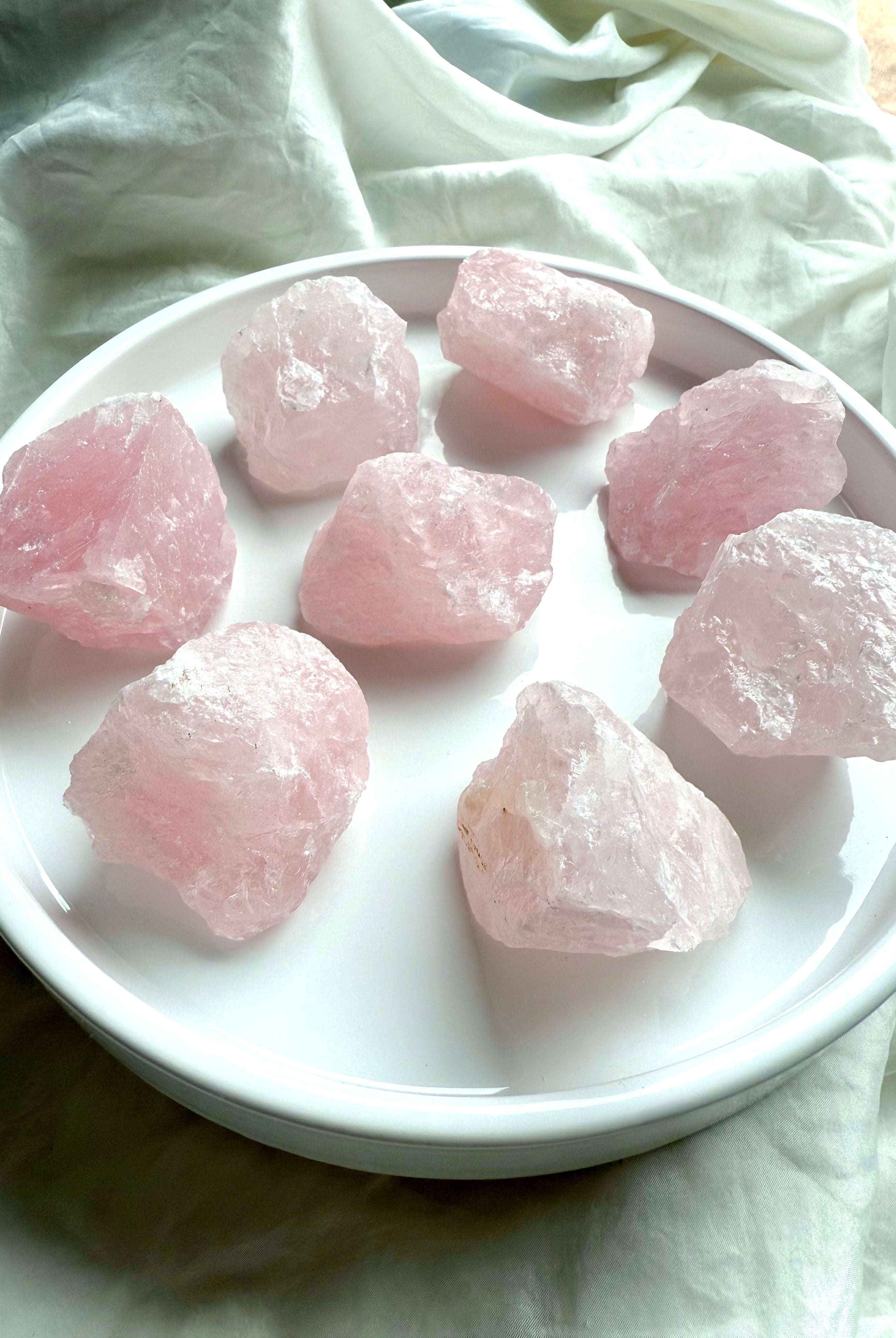 Large raw Rose Quartz crystal chunks from Madagascar on white. Pink stones for Heart chakra healing.