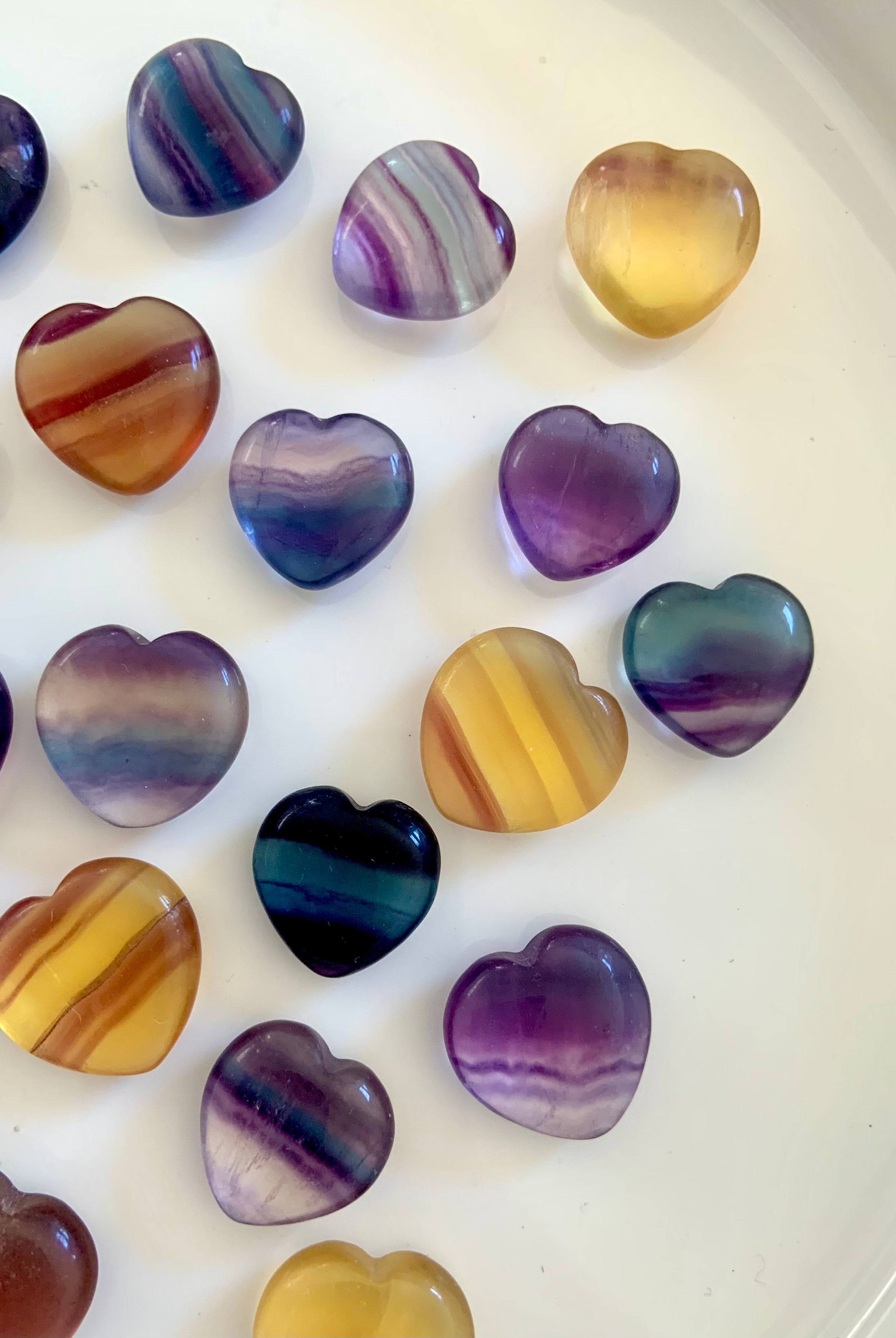 Small Rainbow Fluorite Hearts in a variety of colors including purple, blue magenta, teal, and yellow. Mini crystal heart, banded candy fluorite pocket stones make a sweet little gift + addition to your crystal collection