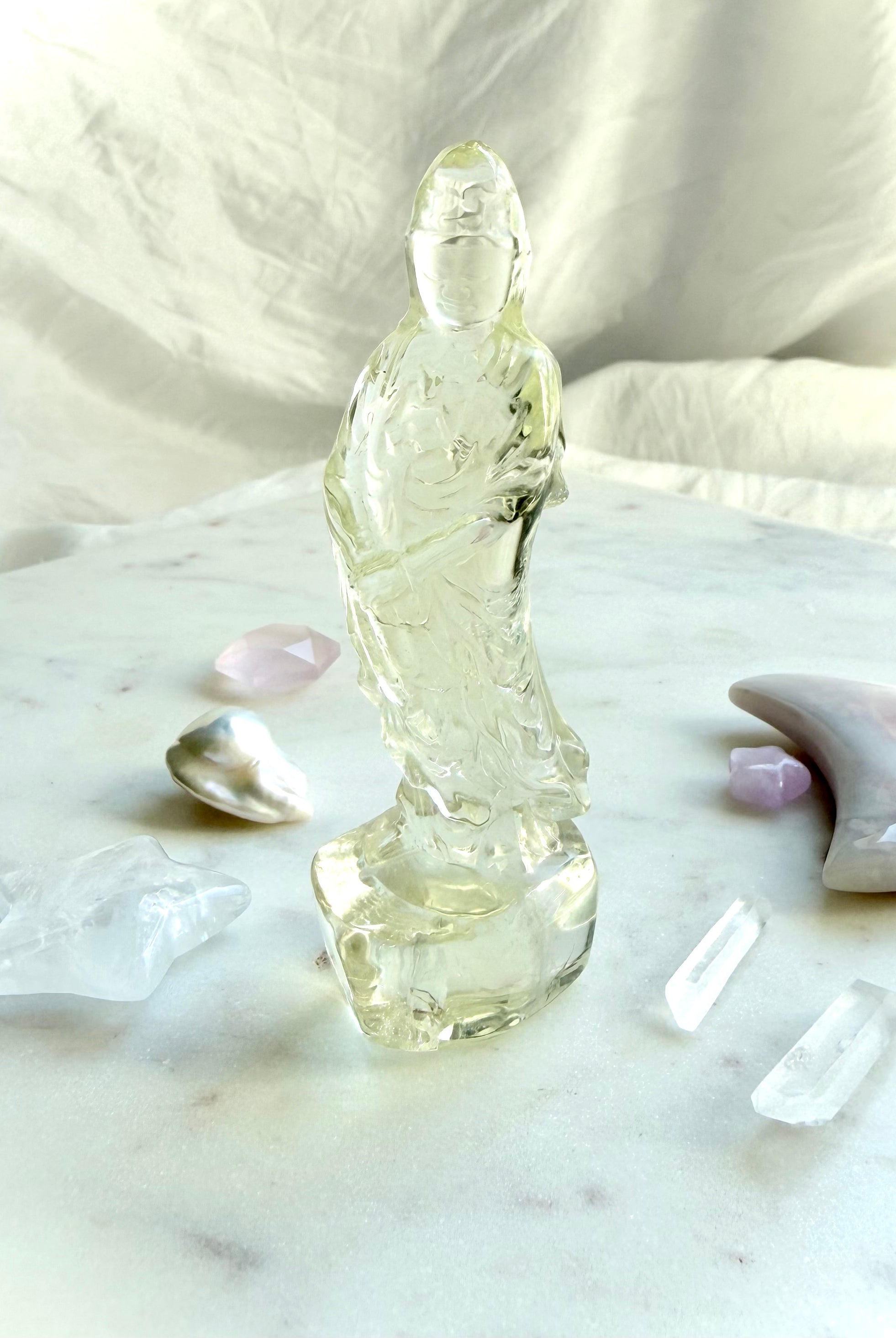 Citrine Quan Yin statue arranged in an altar display with clear quartz points, pearls, and crystal moons for abundance and positivity