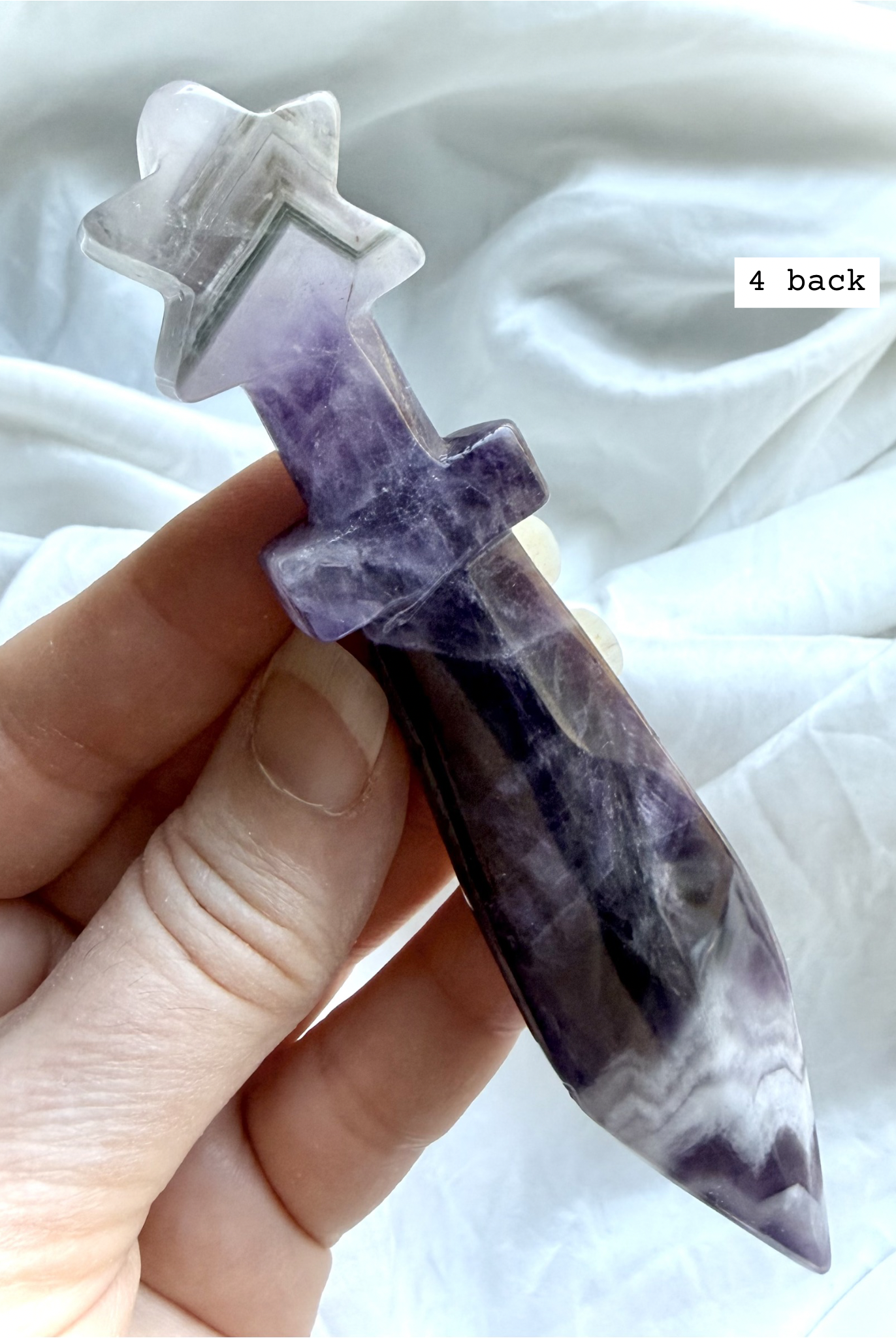 Reverse side of Dream Amethyst crystal dagger carving with layered lavender and white banding