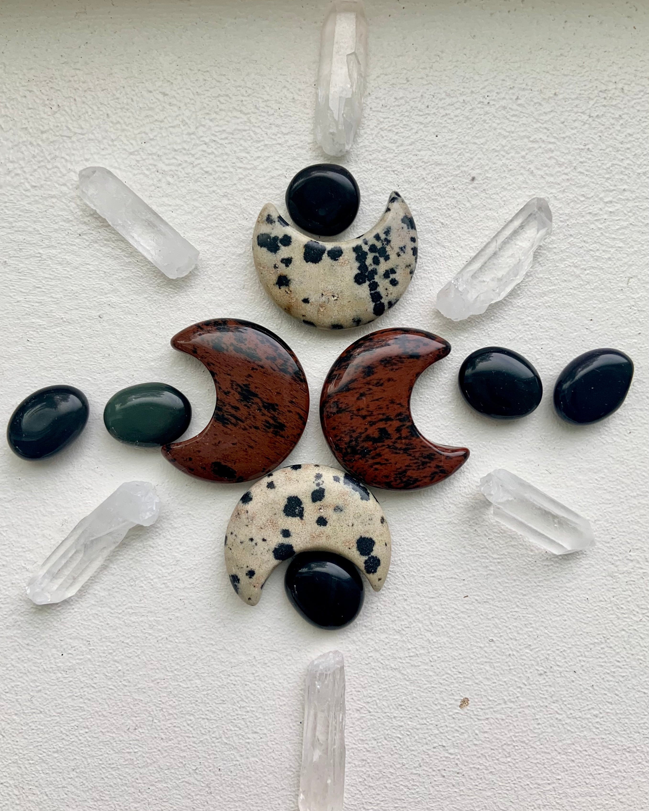 Clear quartz points arranged in moon phase crystal grid with crescent moon carvings for sacred space, energetic protection, and amplification