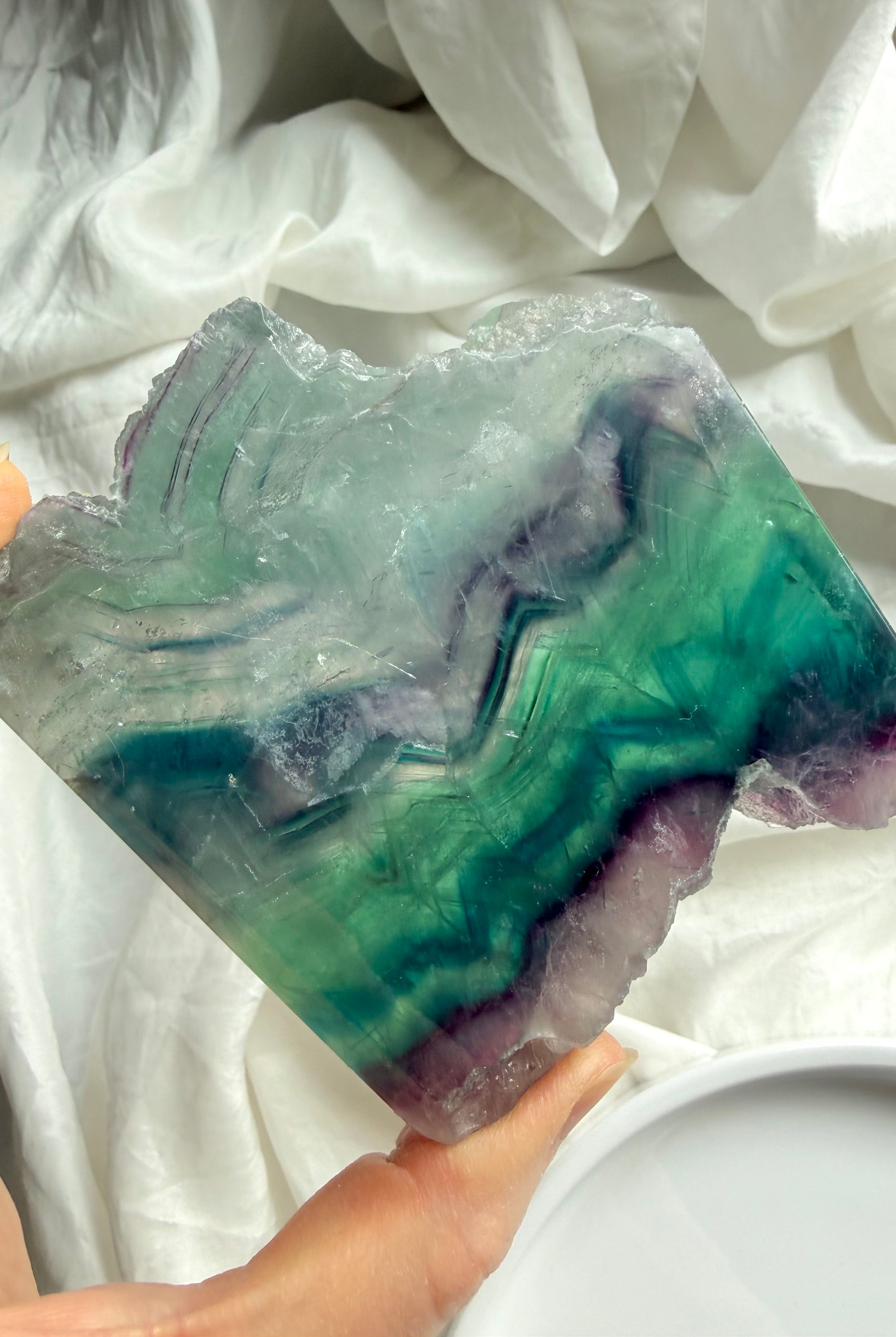 Polished fluorite slab photographed in natural light highlighting teal, green & purple crystal bands