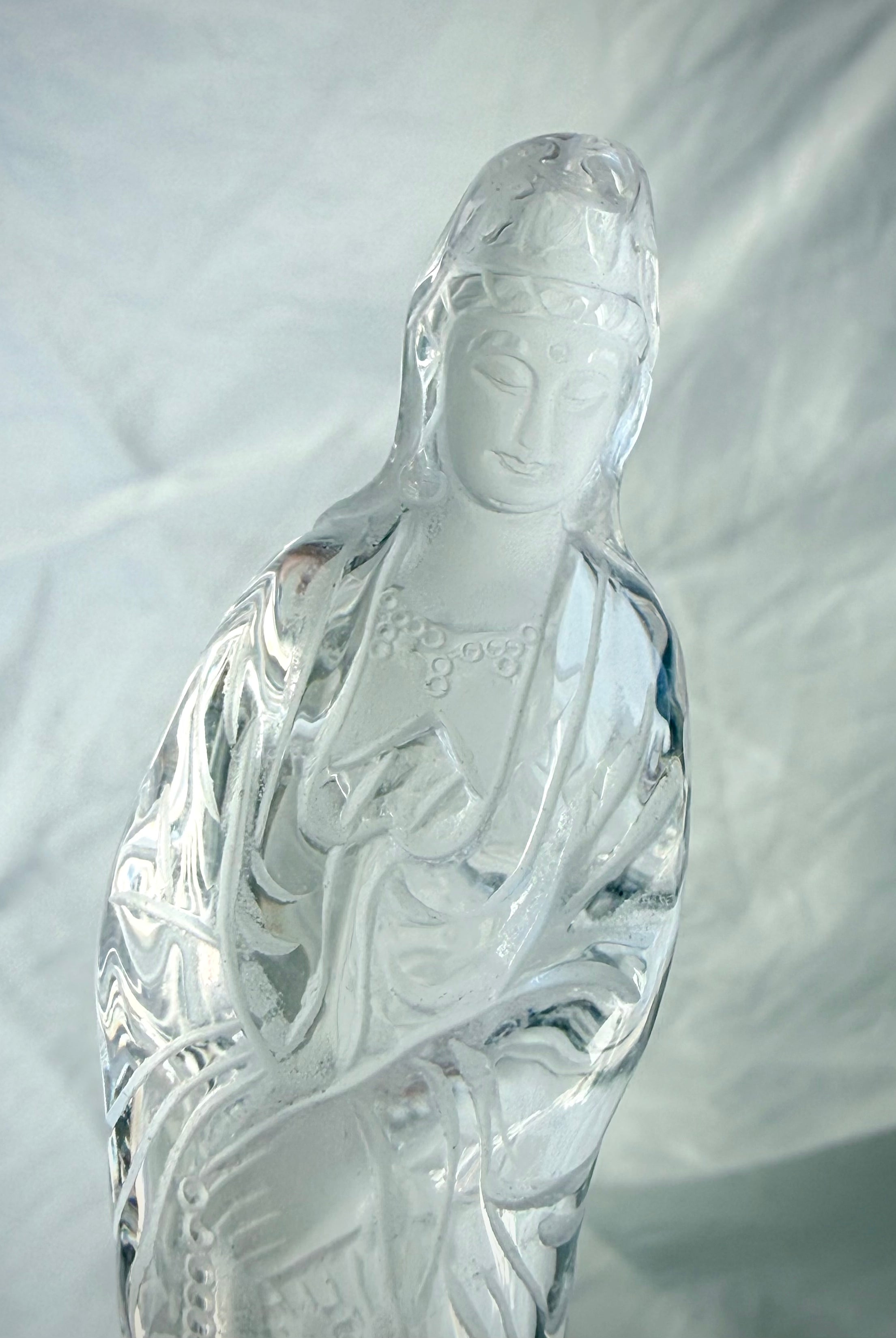 Close up of Collector-quality Quan Yin carving in natural Clear Quartz with graceful lines and peaceful expression