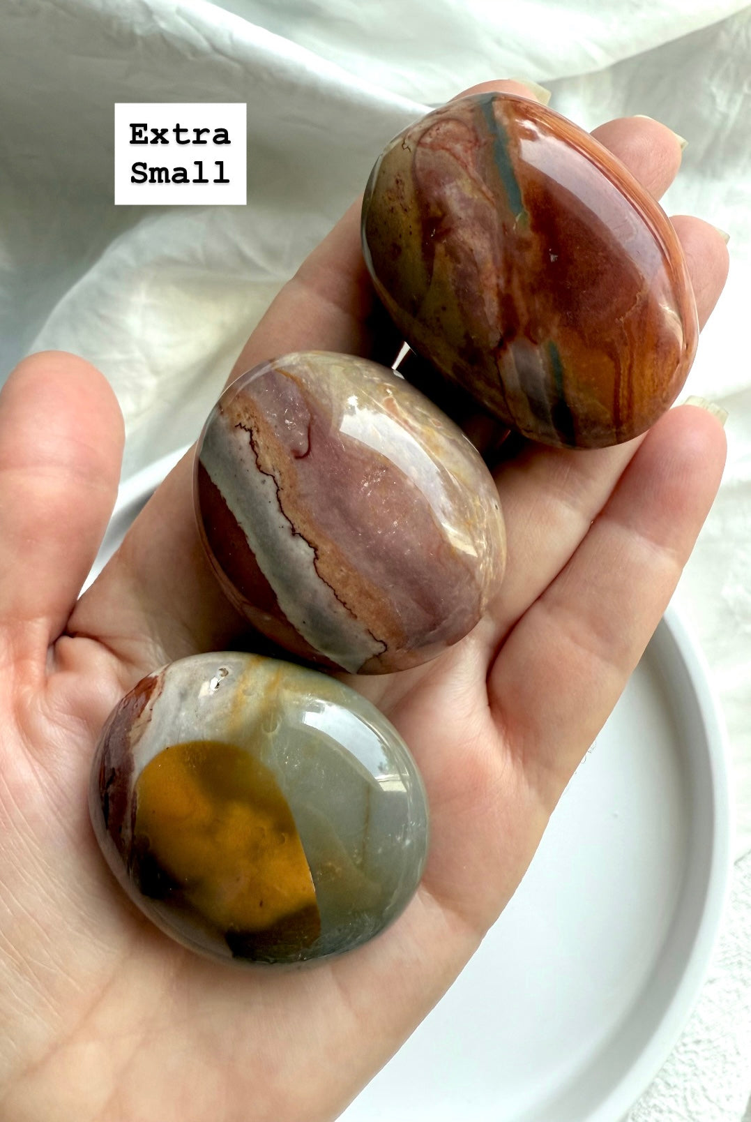 Extra small Polychrome Jasper palm stone shown in hand, perfect pocket stone for grounding & calm.