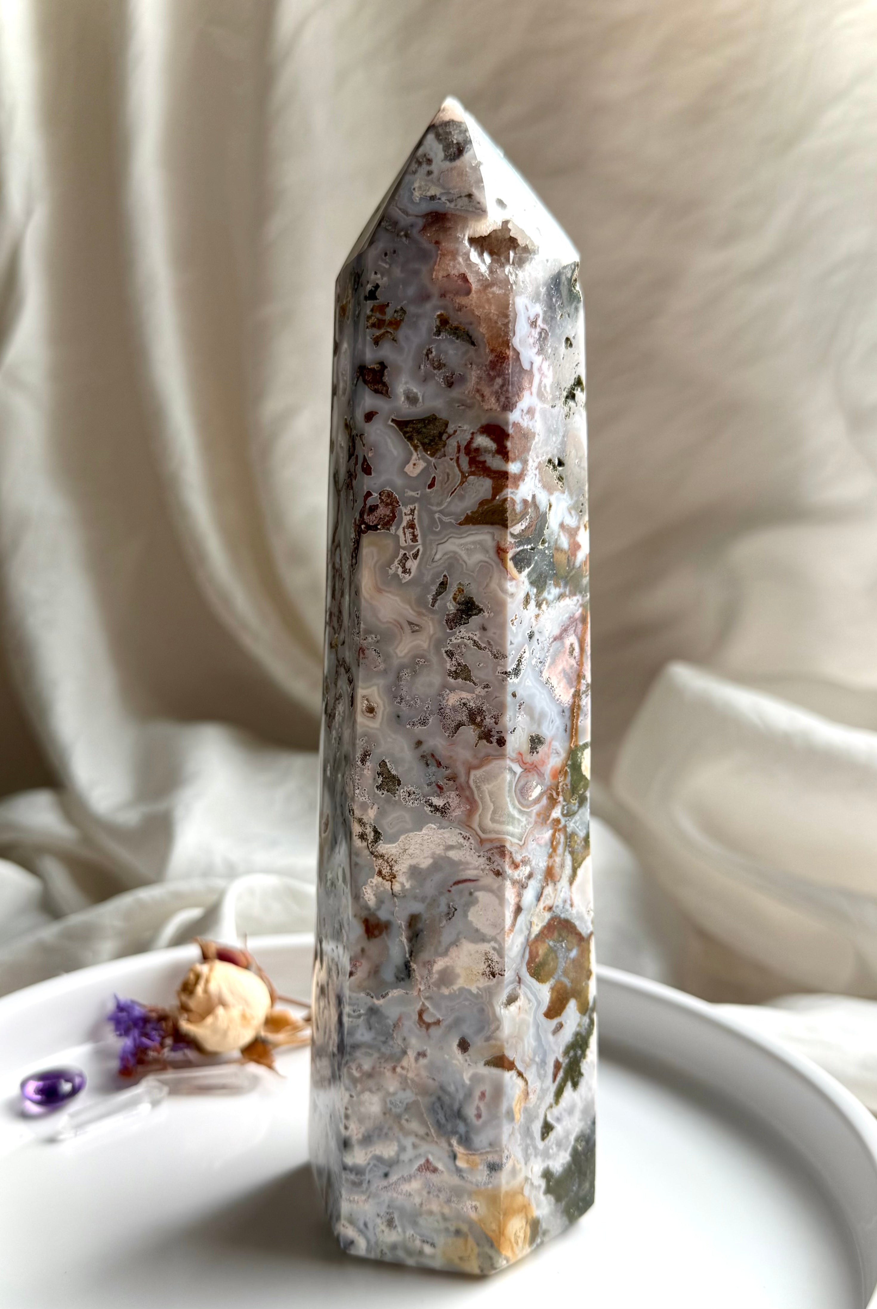 Standing Cosmic Ocean Jasper crystal point with polished faces, ocean-like patterns, and grounding earthy inclusions