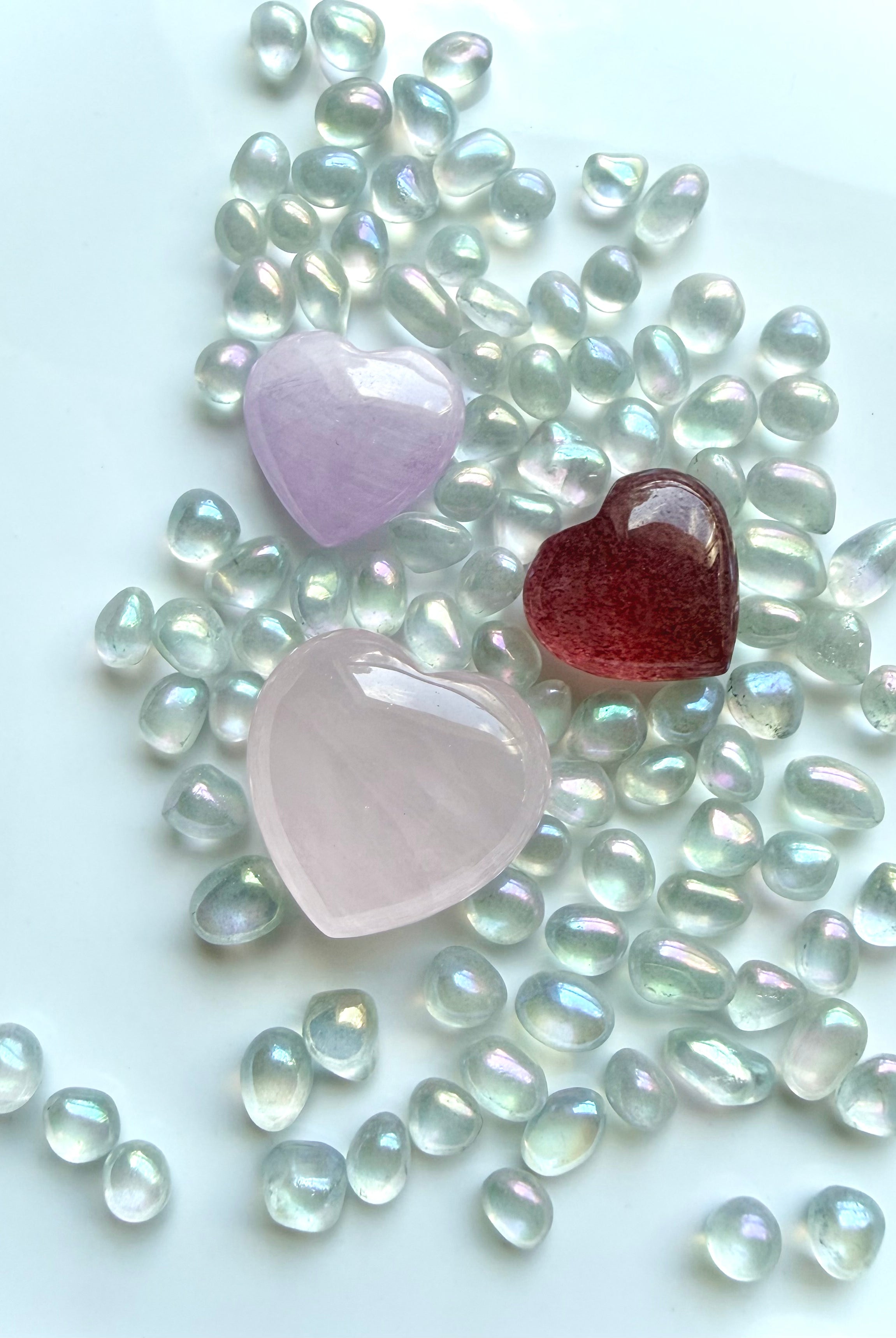 Three mini crystal hearts with aura crystal confetti including rose quartz, strawberry quartz, and kunzite healing stones