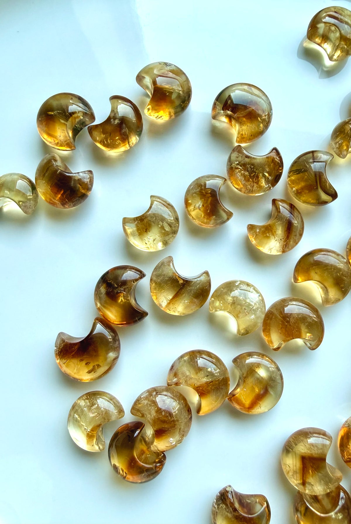 Mini Citrine moon carvings showing translucent golden honey tones, natural color zoning and inner dimension