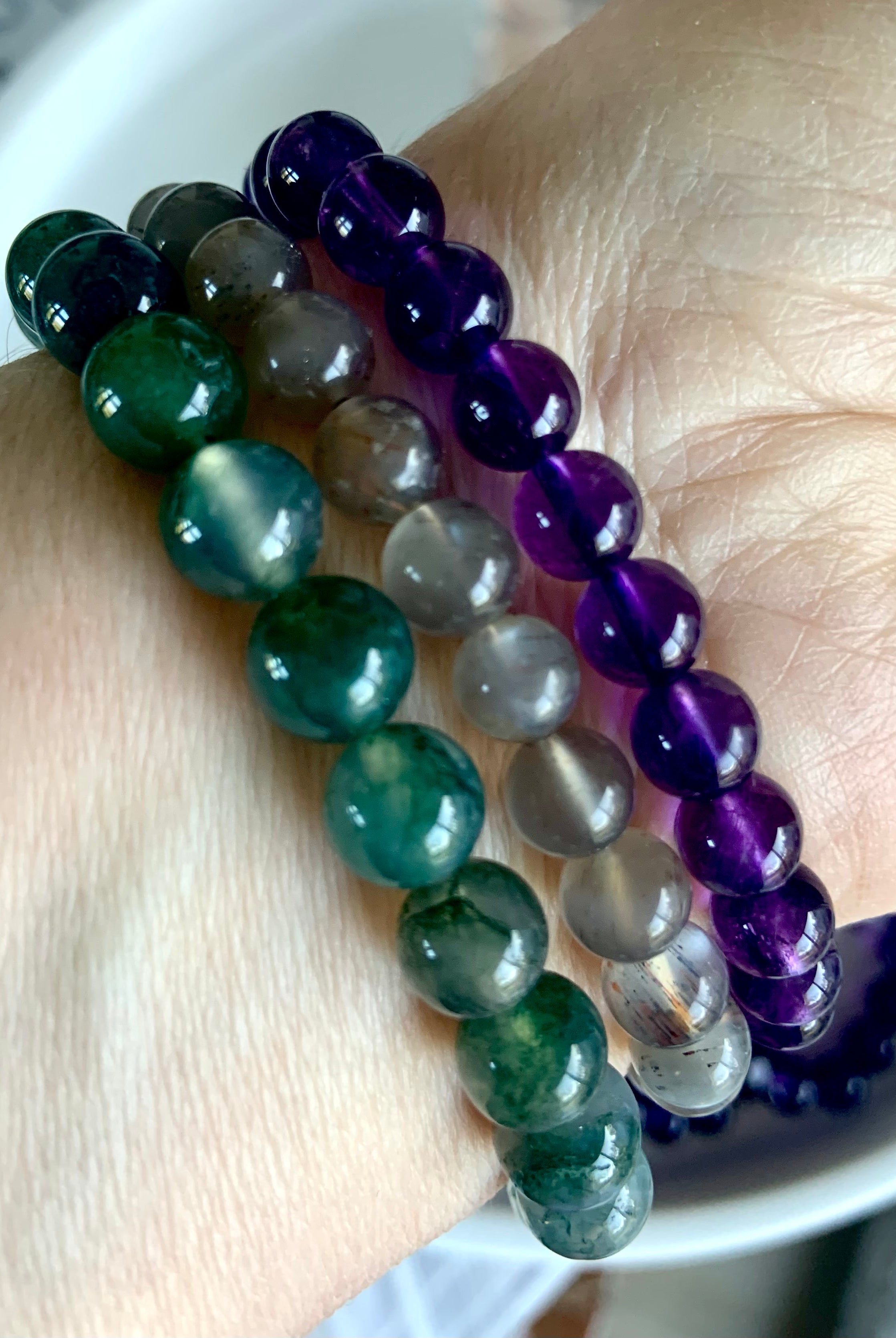 A combination of three healing crystal bracelets worn together