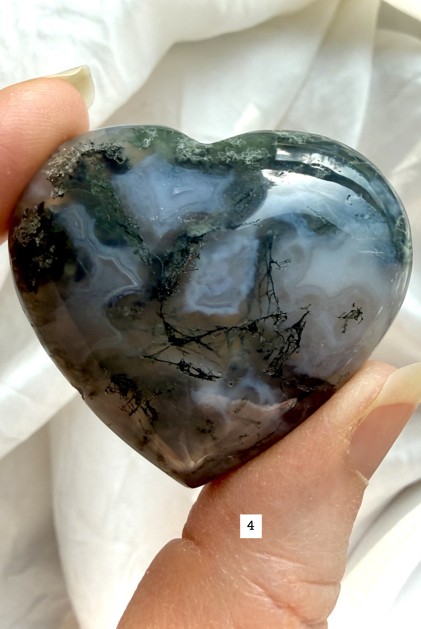 moss agate heart carving option 4 in hand with rich green inclusions and natural landscape pattern