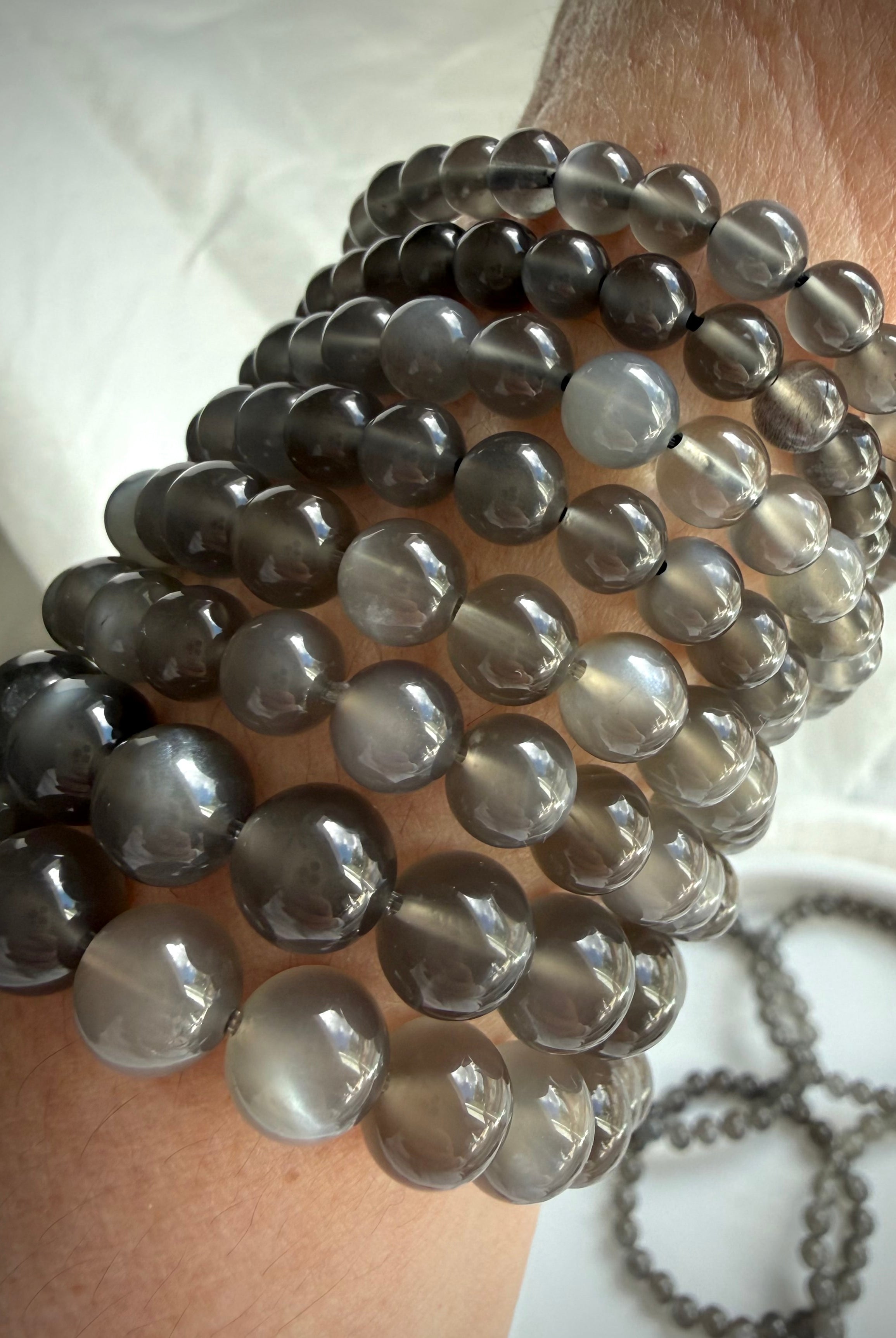 Black Moonstone bracelets worn on wrist showcasing silky moonlit shimmer and translucent charcoal gray gemstone beads