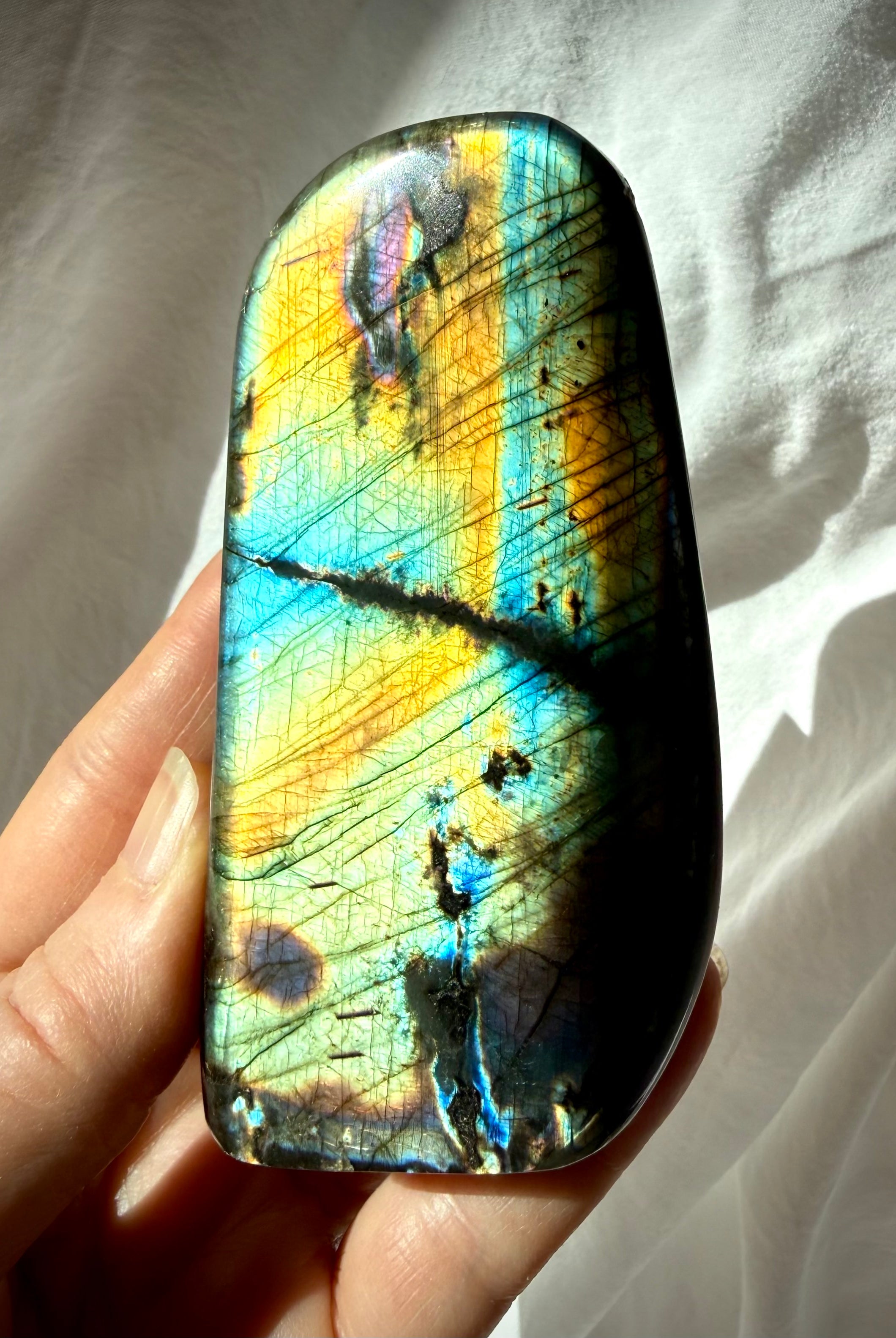 Rainbow Labradorite freeform held in hand, crystal for intuition, protection, transformation, and Third Eye Chakra work
