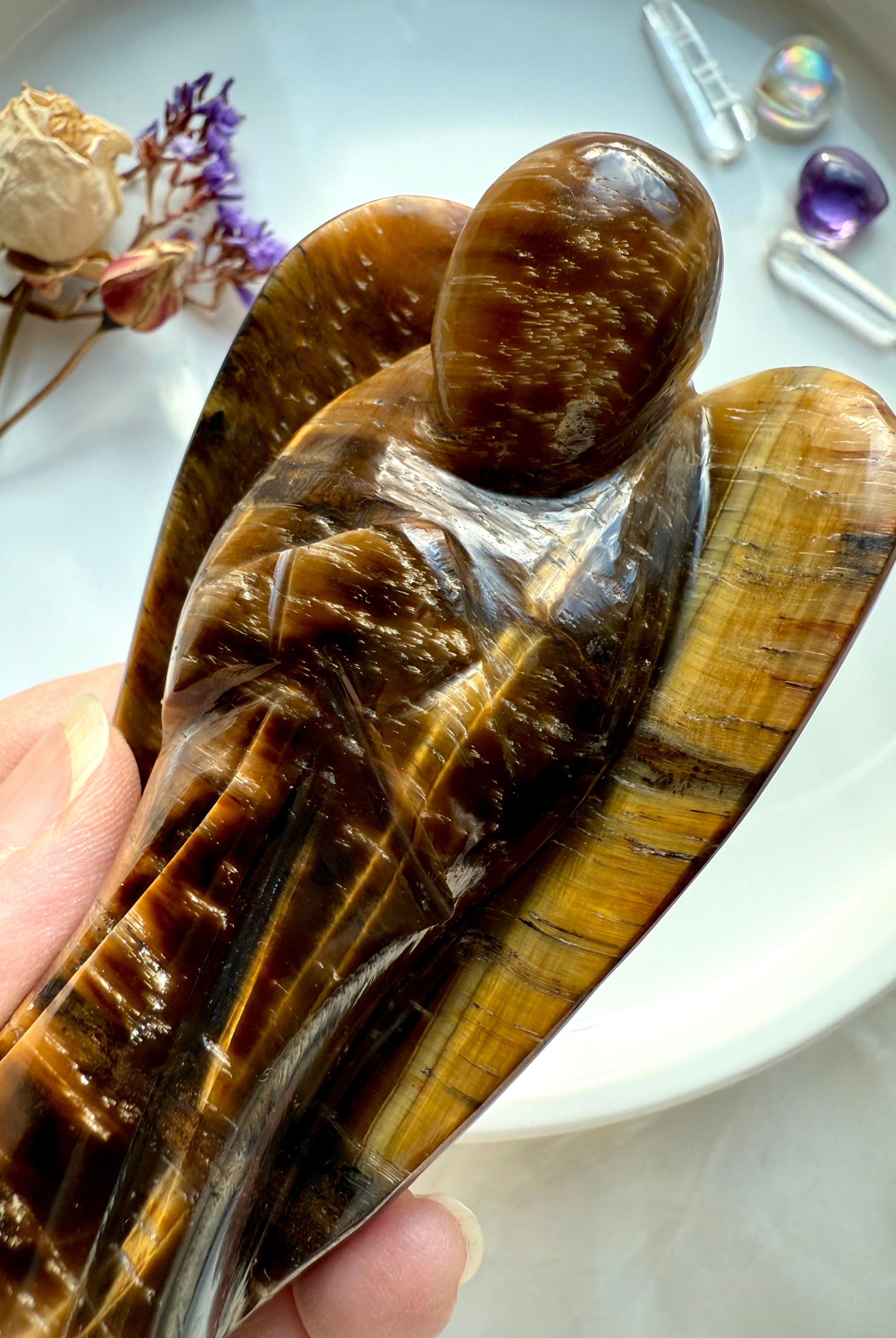 Close-up of polished Tiger’s Eye crystal angel showing detailed golden bands and natural shimmer