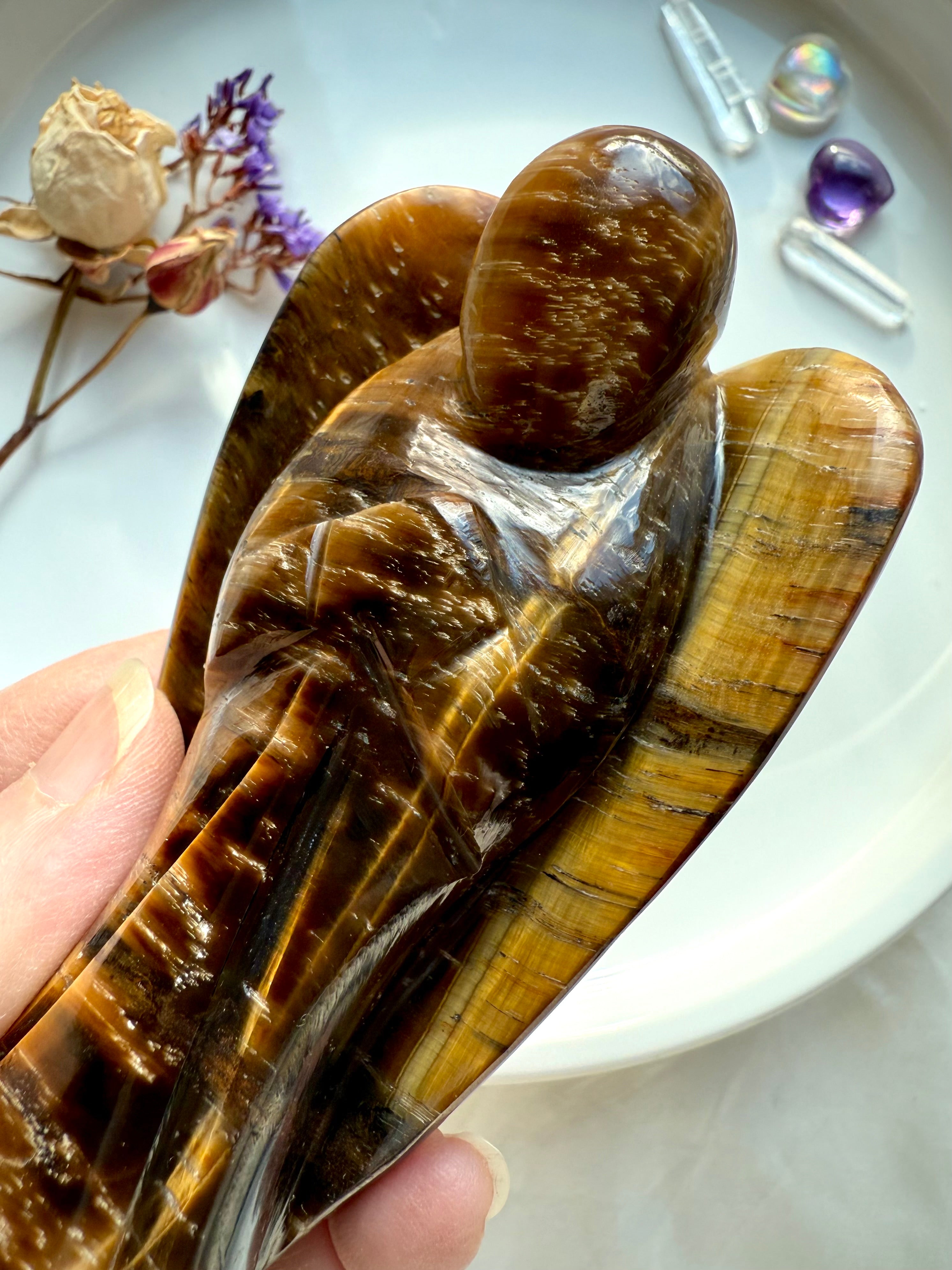 Close-up of polished Tiger’s Eye crystal angel showing detailed golden bands and natural shimmer