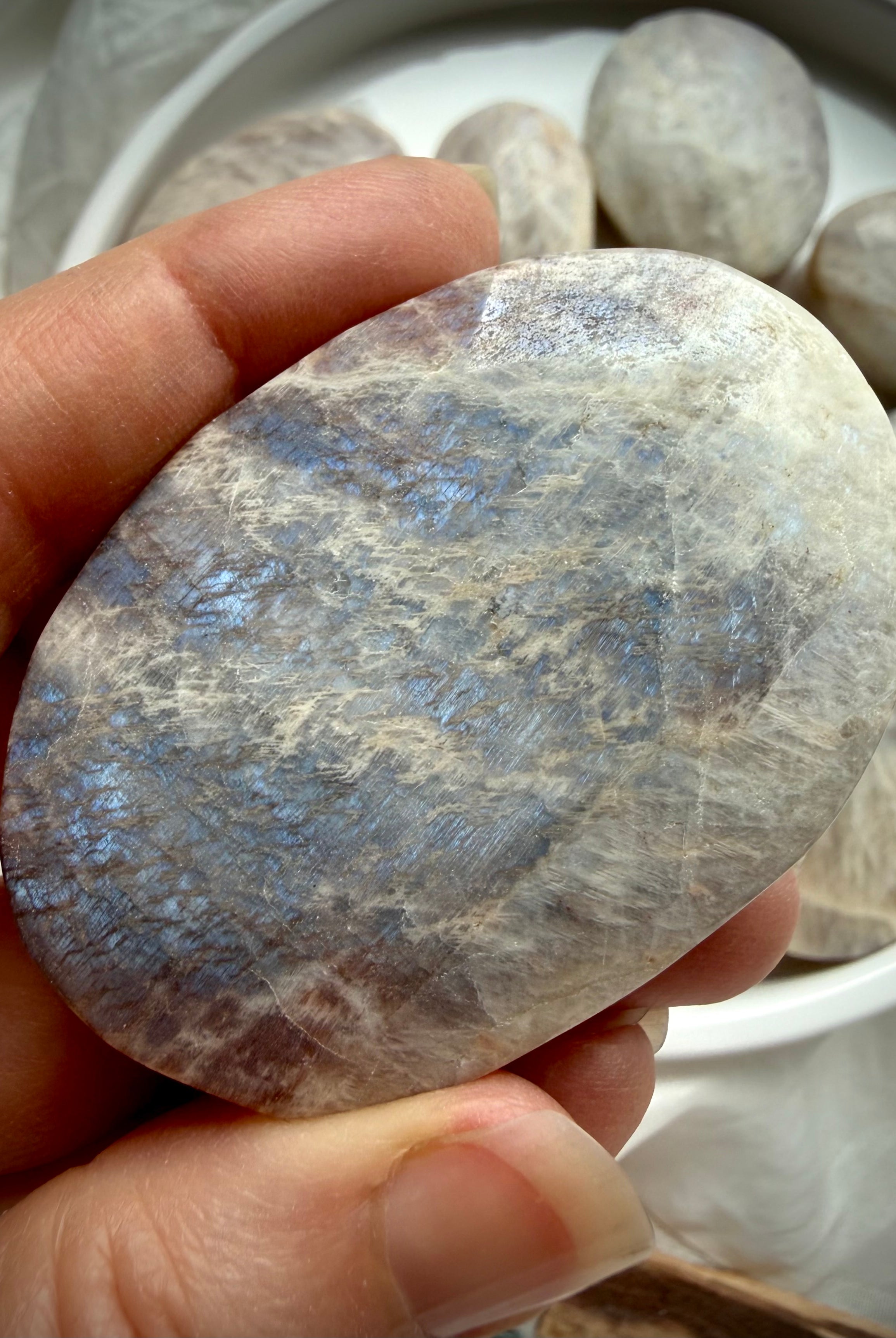 large belomorite moonstone palm stone with blue flash and earthy gray feldspar tones