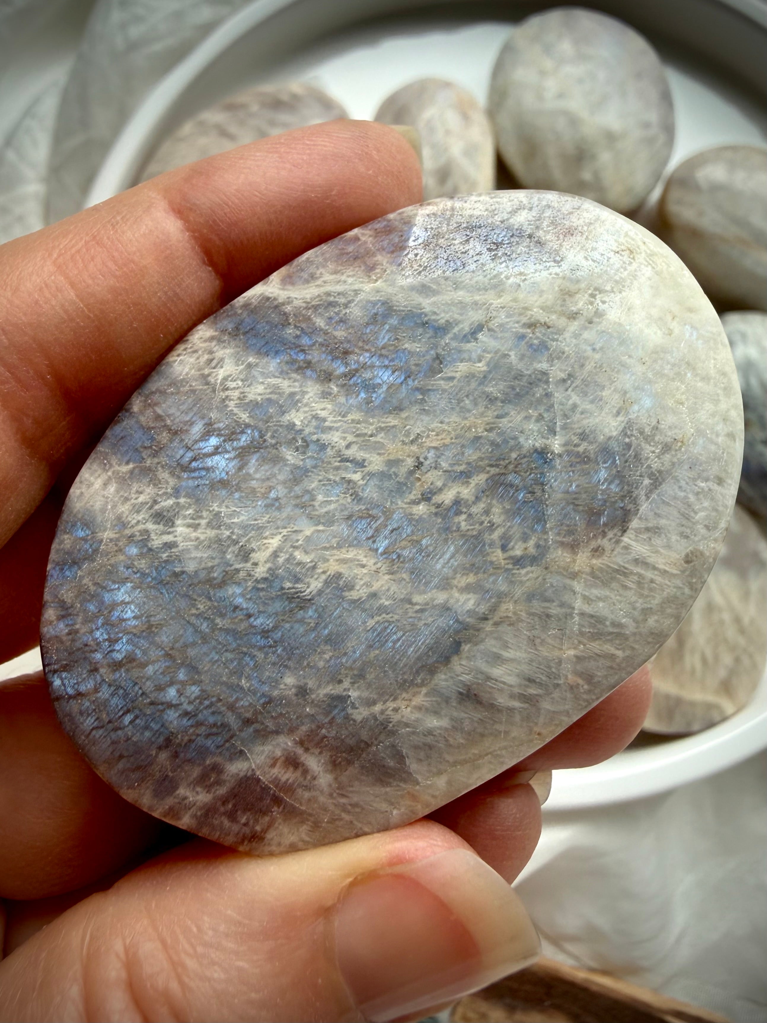 large belomorite moonstone palm stone with blue flash and earthy gray feldspar tones