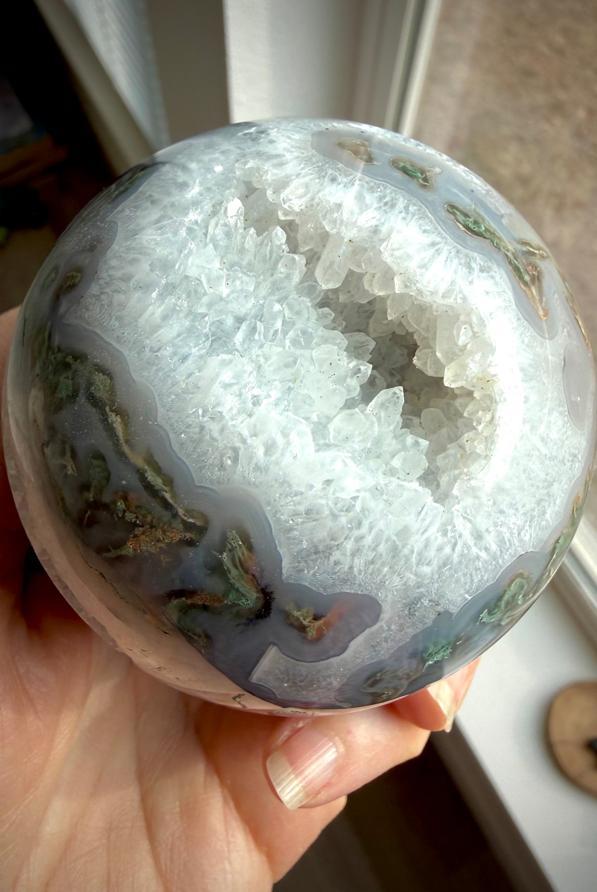 Moss Agate geode sphere with sparkling Quartz crystal cavern, luminous white Quartz and layered blue-gray chalcedony banding