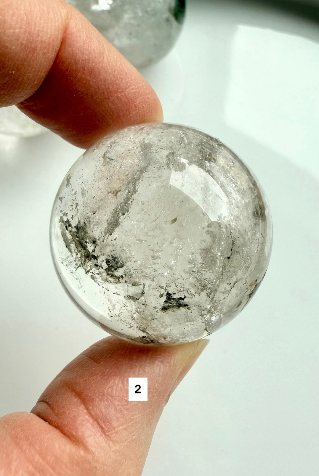 close-up of garden quartz sphere – clear crystal with moss-like inclusions for meditation
