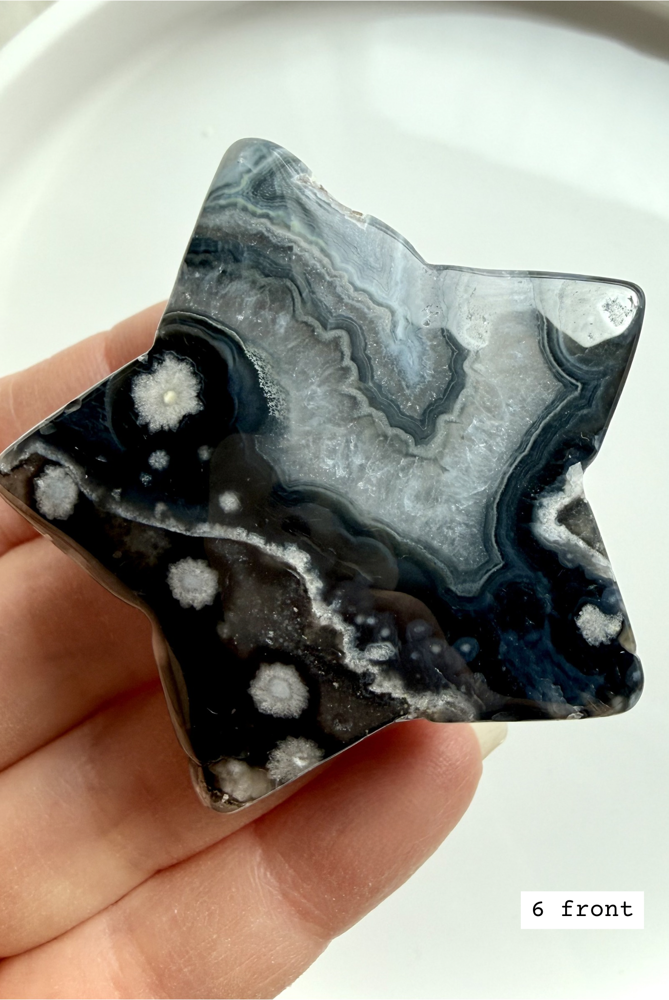 black flower agate star carving #6 front showing detailed petal-like inclusions and polished finish