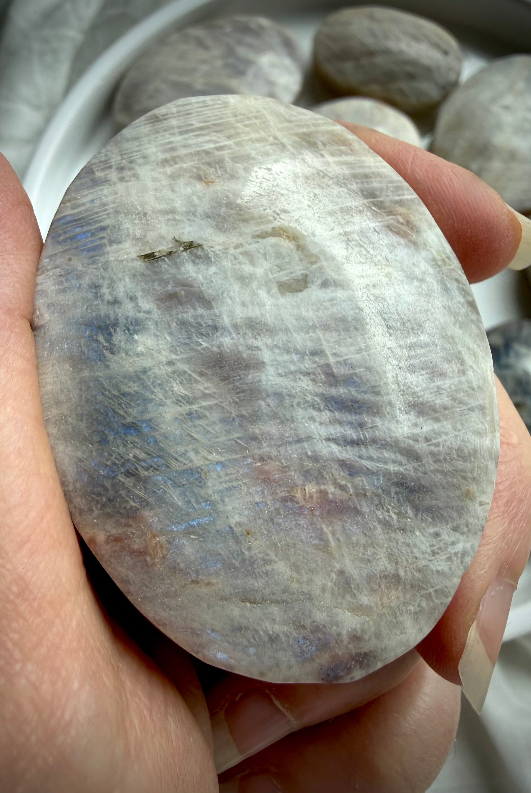 belomorite moonstone palm stone with blue flash, silvery shimmer, and natural sunstone inclusions in feldspar matrix