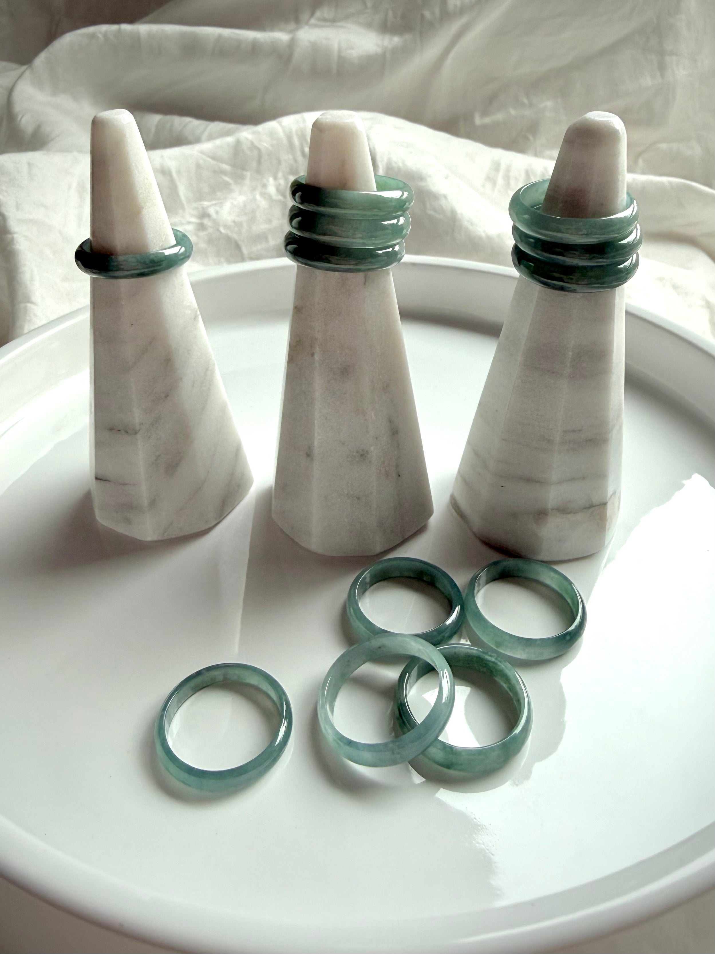 Natural Guatemalan Blue Water jade ring bands shown on marble display stands