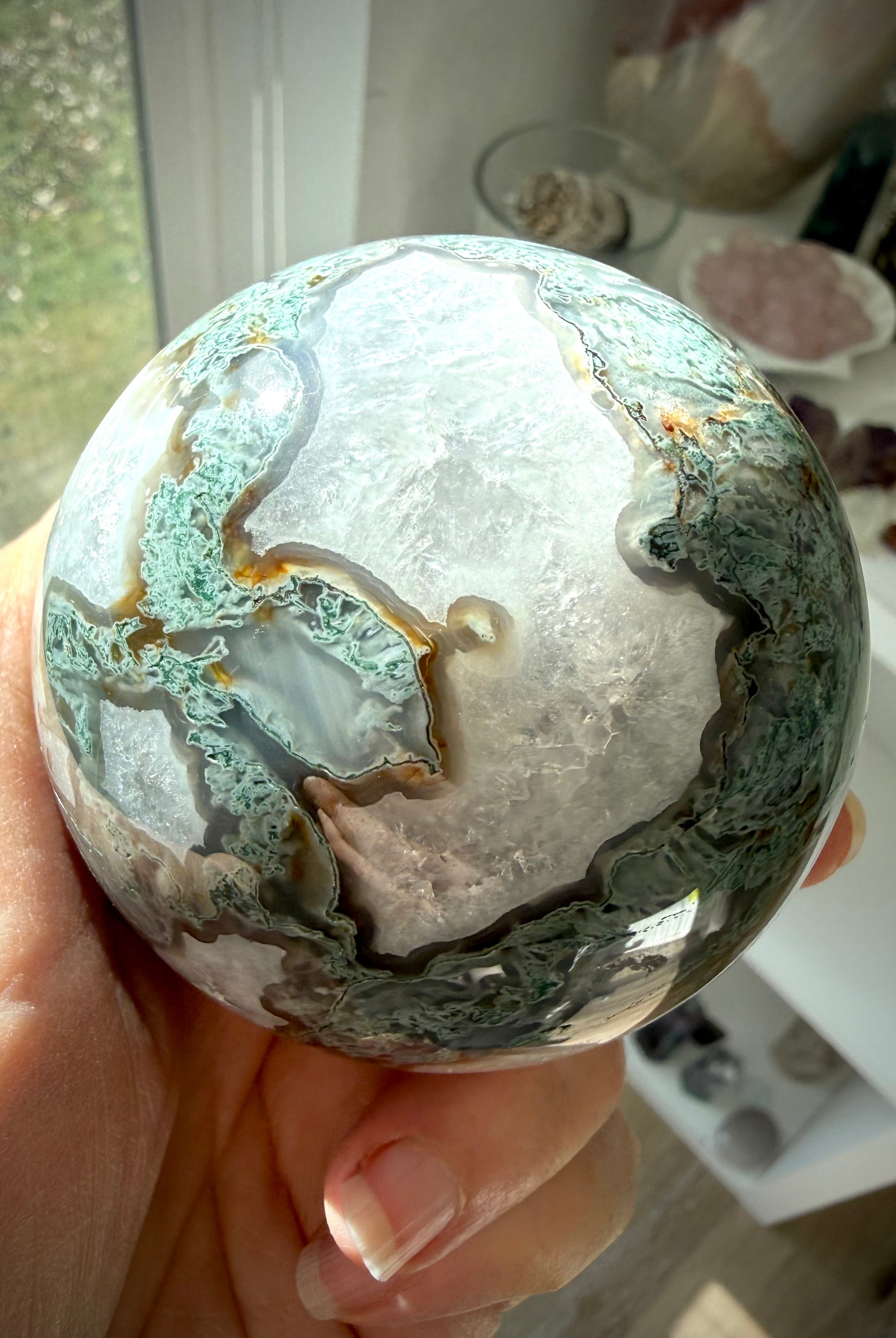 Moss Agate crystal sphere glowing in sunlight with Quartz formations, druzy texture, and scenic green inclusions