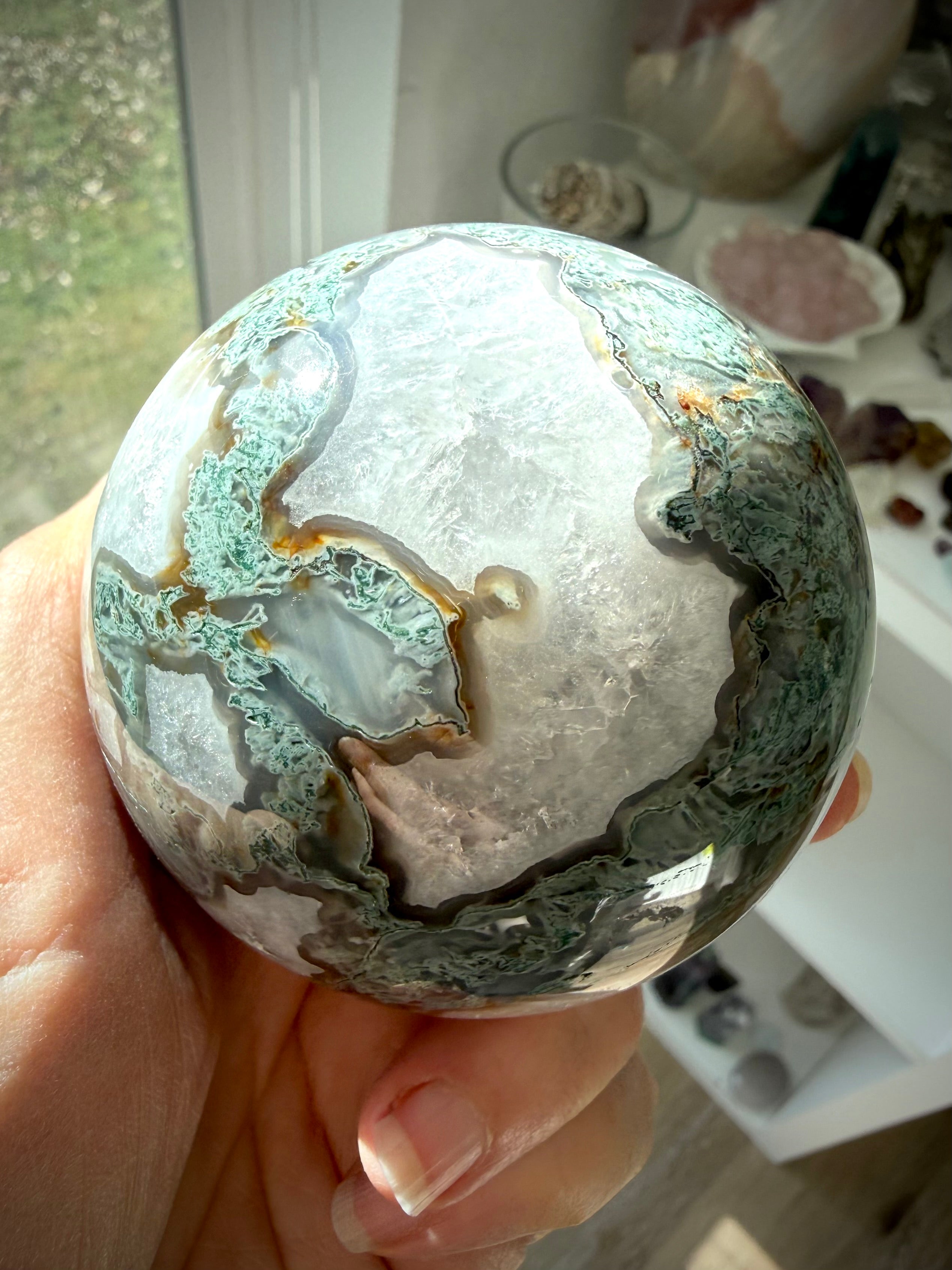 Moss Agate crystal sphere glowing in sunlight with Quartz formations, druzy texture, and scenic green inclusions