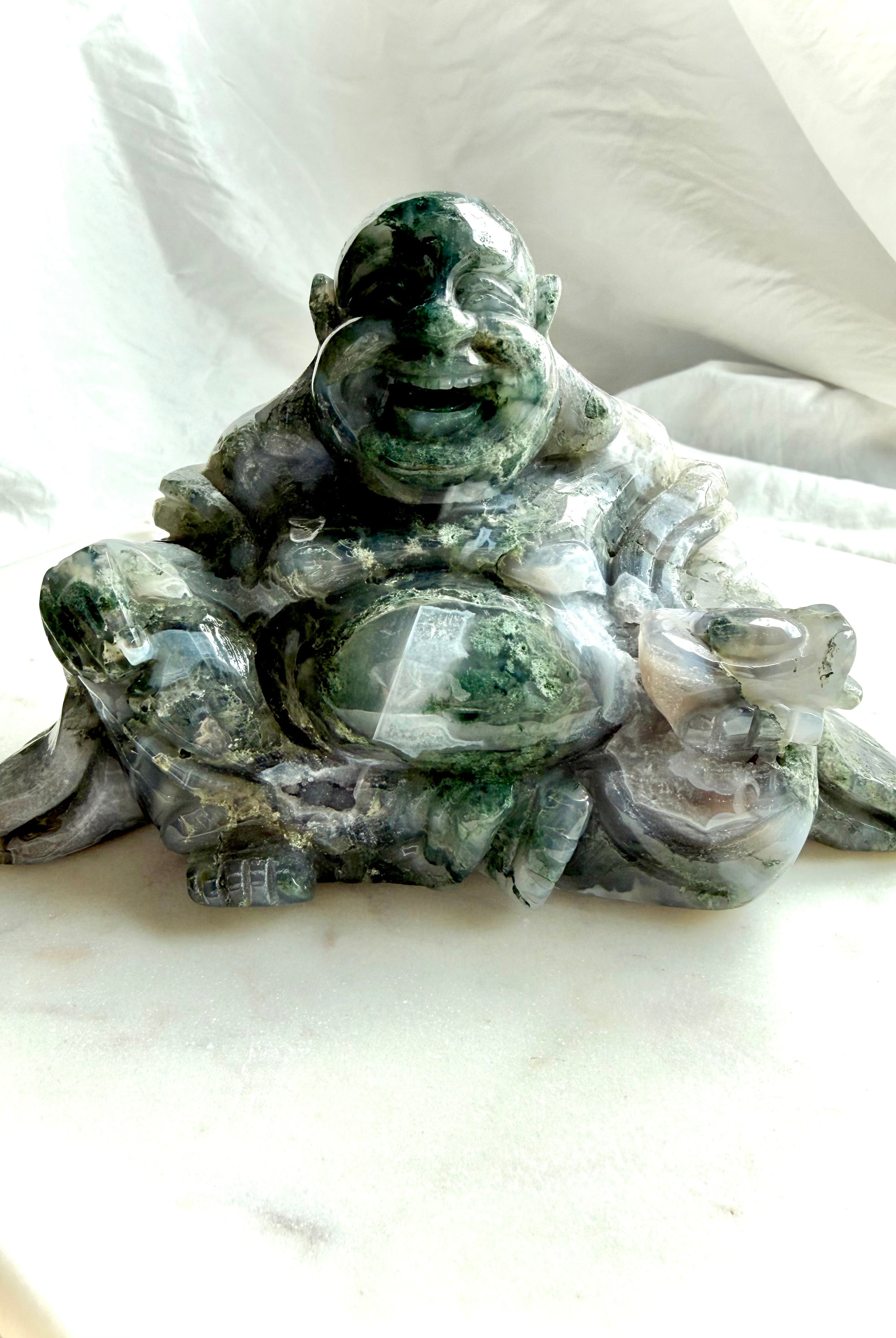 Front view of a Large Moss Agate Laughing Buddha crystal statue with scenic green inclusions