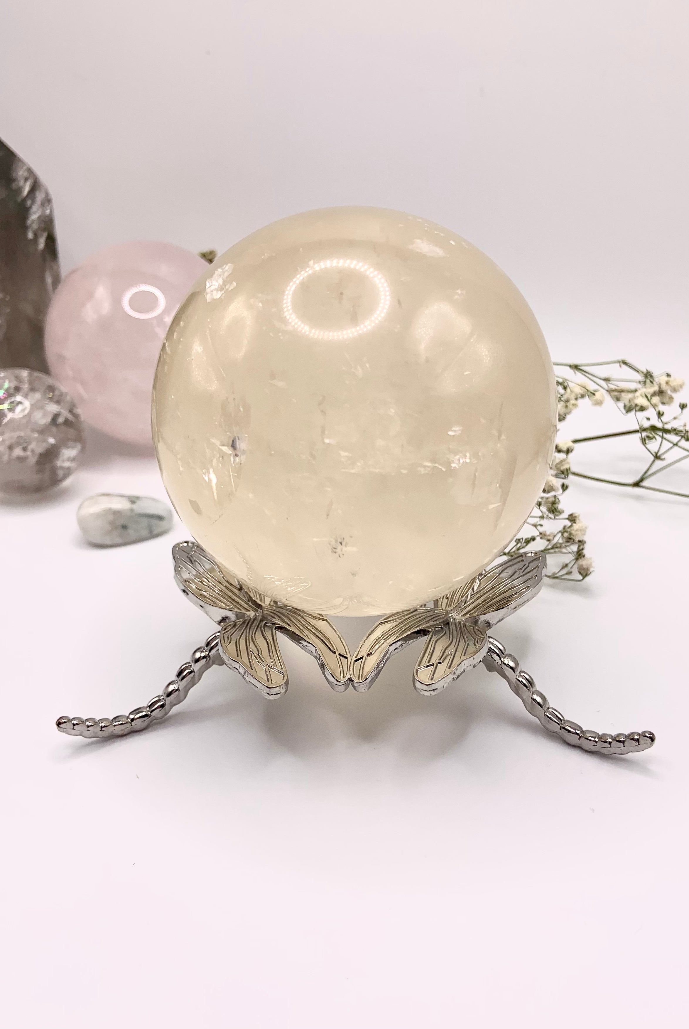 The larger dragonfly crystal sphere holder shown with a 72mm honey calcite sphere