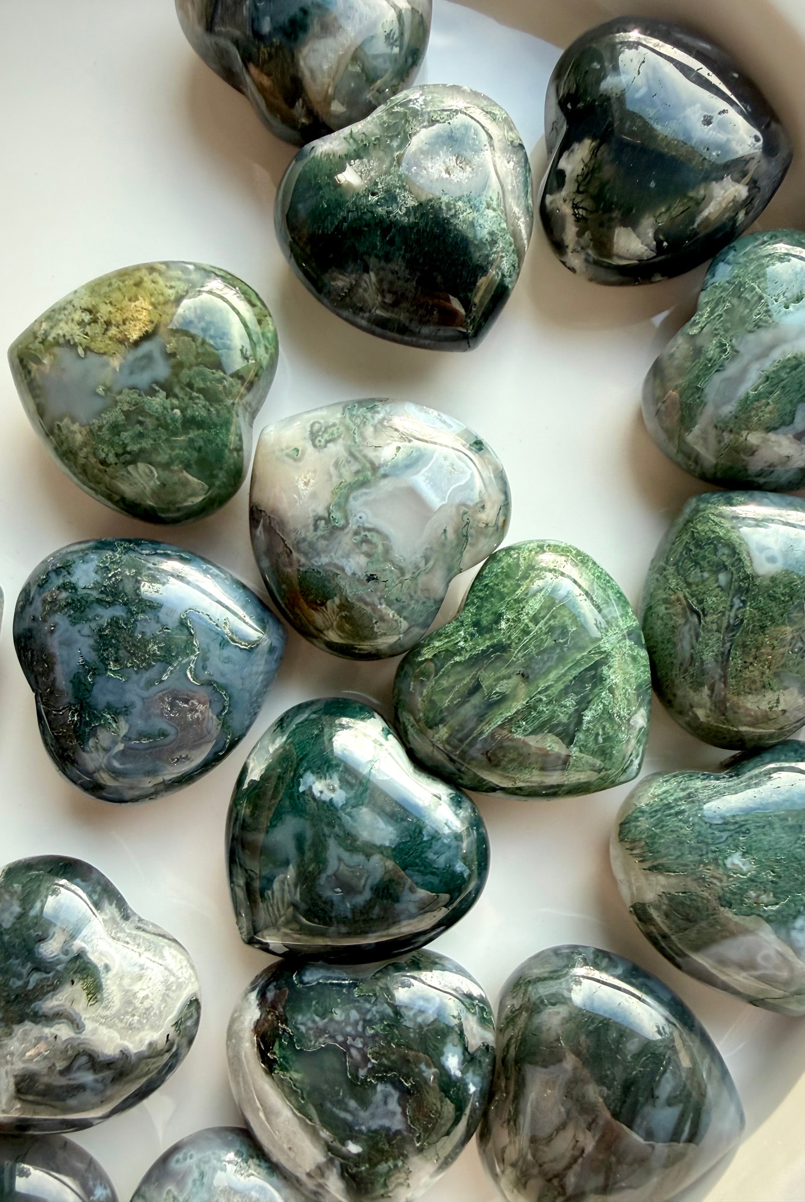 Polished Moss Agate hearts arranged for crystal healing and spiritual gifting, each with unique natural patterns