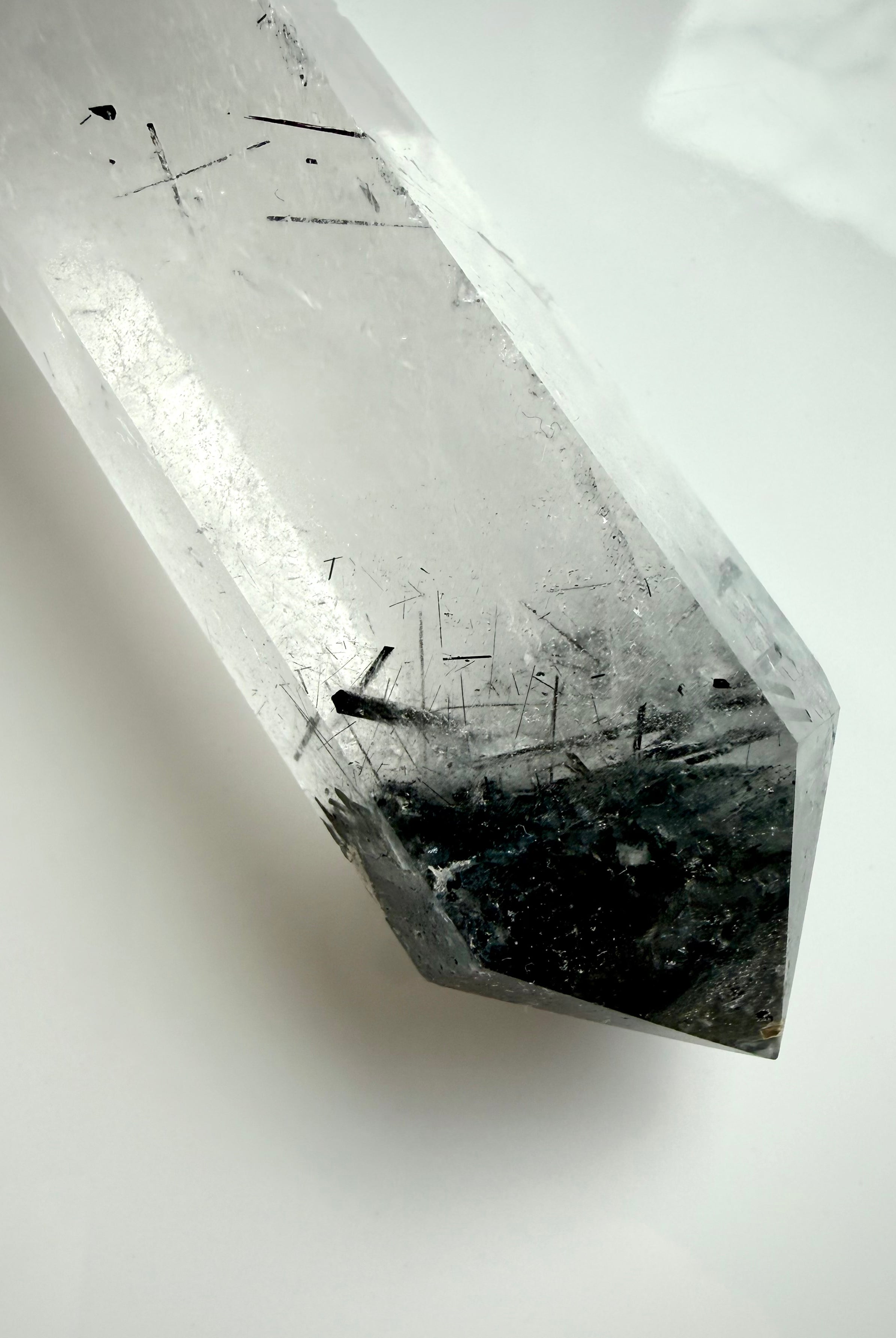 black tourmaline in quartz crystal point with polished facets and internal needle inclusions