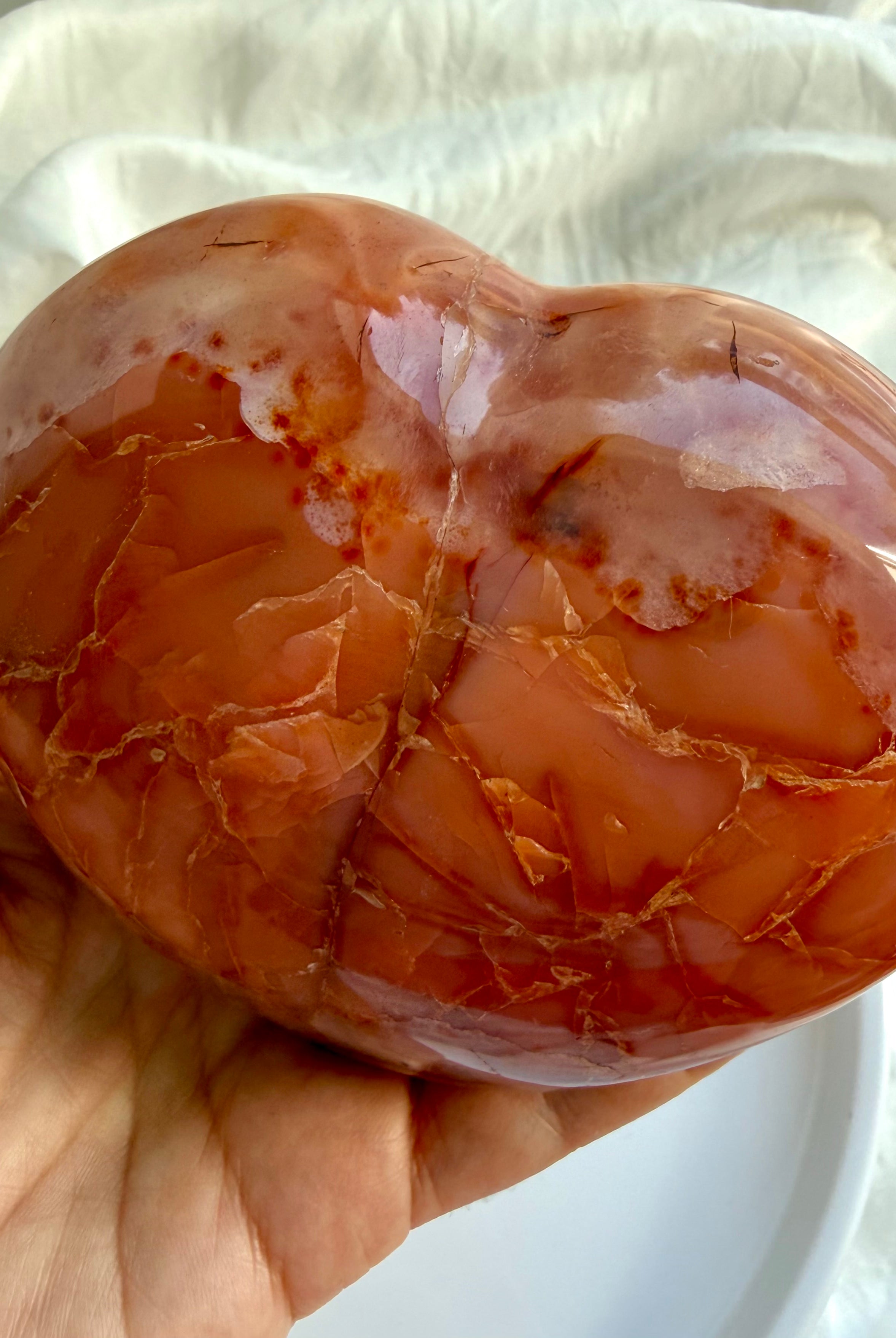 Close up of polished Carnelian geode heart with intricate natural patterns and druzy details