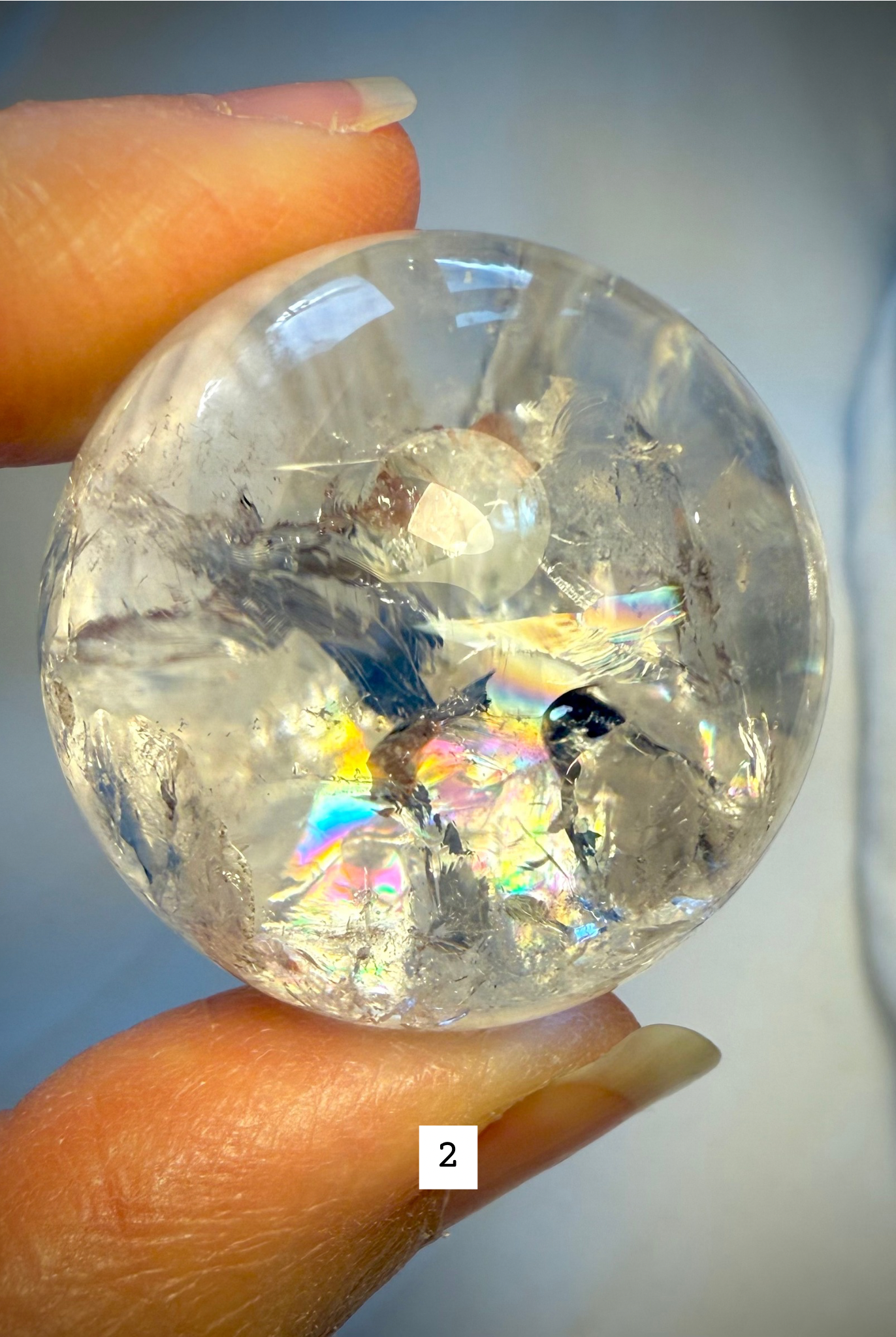 Macro photo of Rainbow Quartz sphere #2 with bold rainbow flash and internal clarity, perfect for chakra healing.