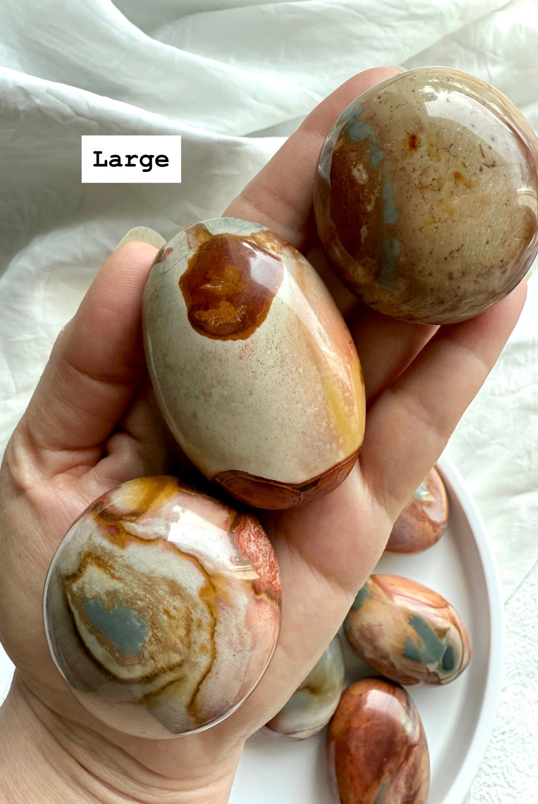 Large Polychrome Jasper palm stone shown in hand, with earthy color swirls & grounding energy.