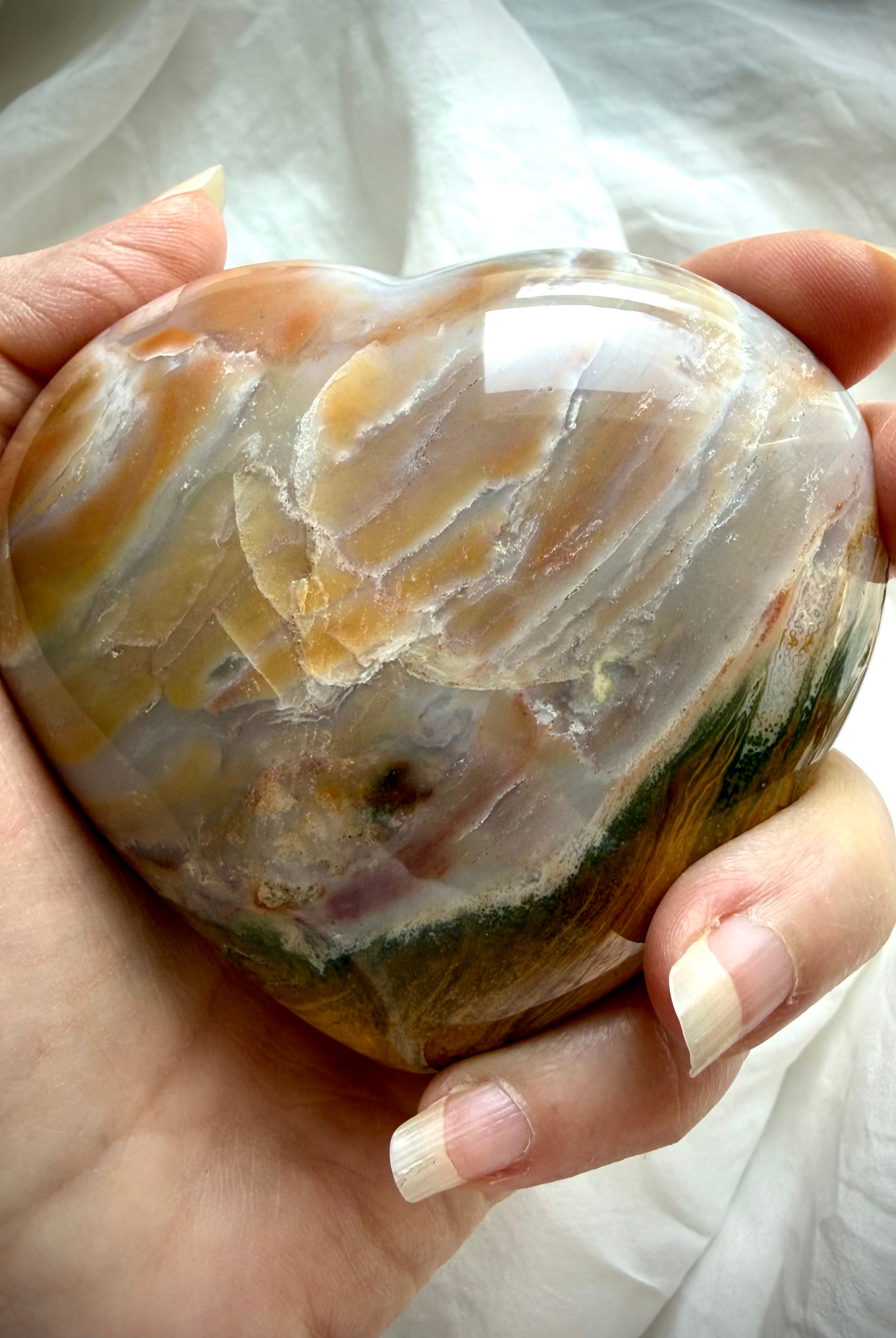 Ocean Jasper heart crystal with natural sea jasper banding, earthy green and warm brown layers, polished meditation stone shown handheld
