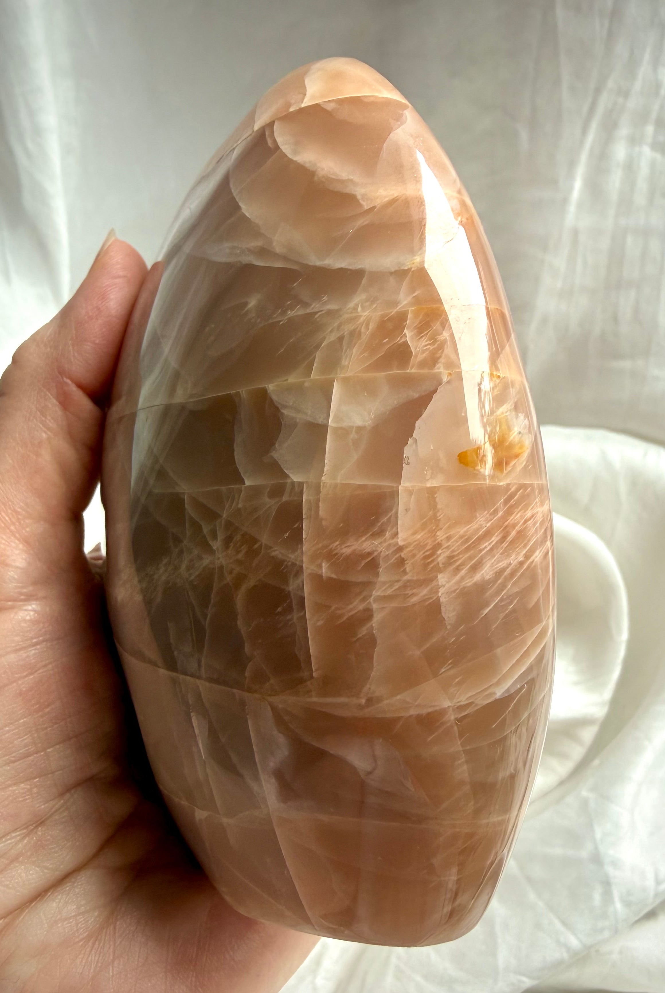 Side view of Peach Moonstone freeform display piece showing natural stone patterns & peachy shimmer