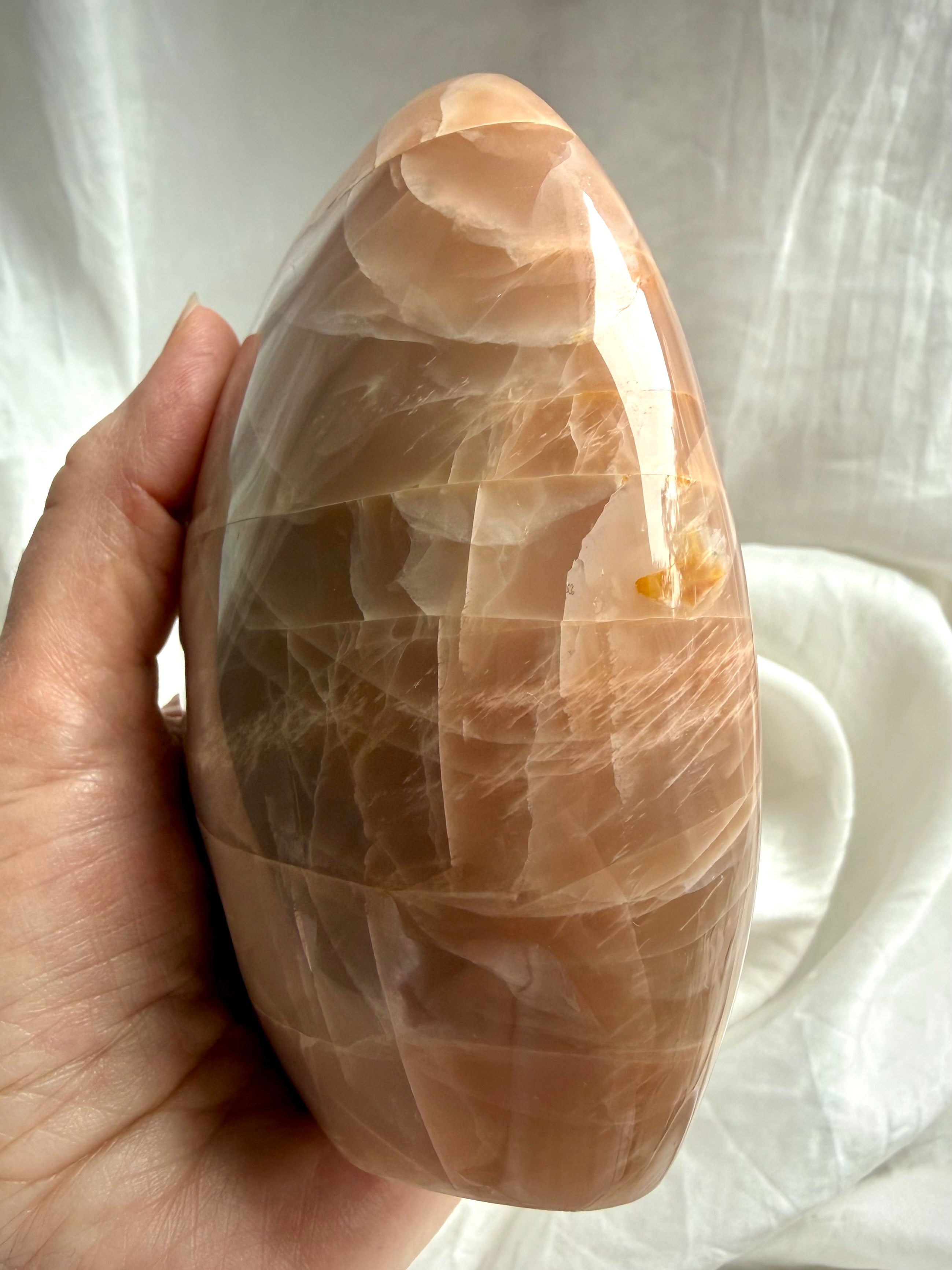 Side view of Peach Moonstone freeform display piece showing natural stone patterns & peachy shimmer