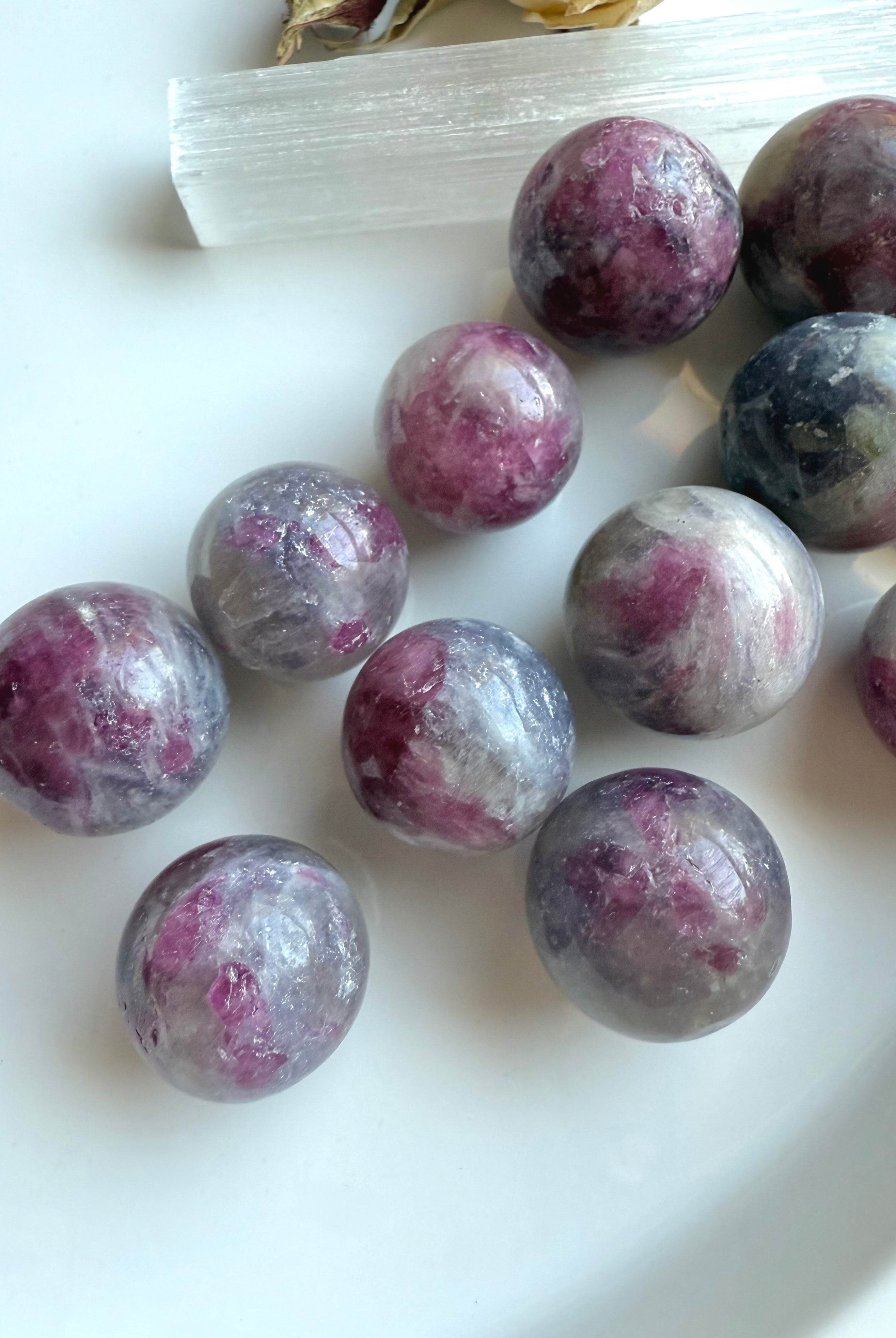 Closeup of polished Unicorn Stone mini spheres highlighting pink tourmaline and lepidolite matrix